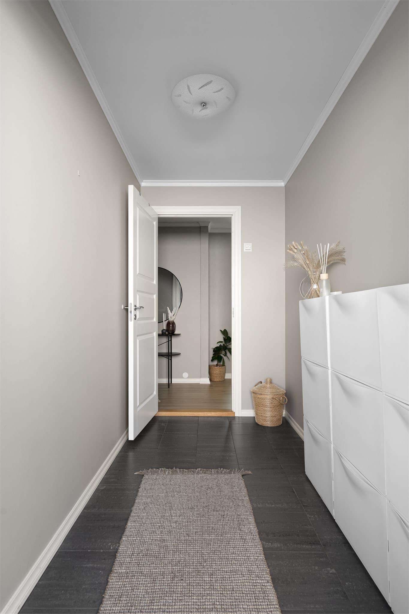 Fra terrassen kommer du inn i en lys og innbydende entré med praktiske fliser på gulv. Her er det plass til sko og oppbevaring.