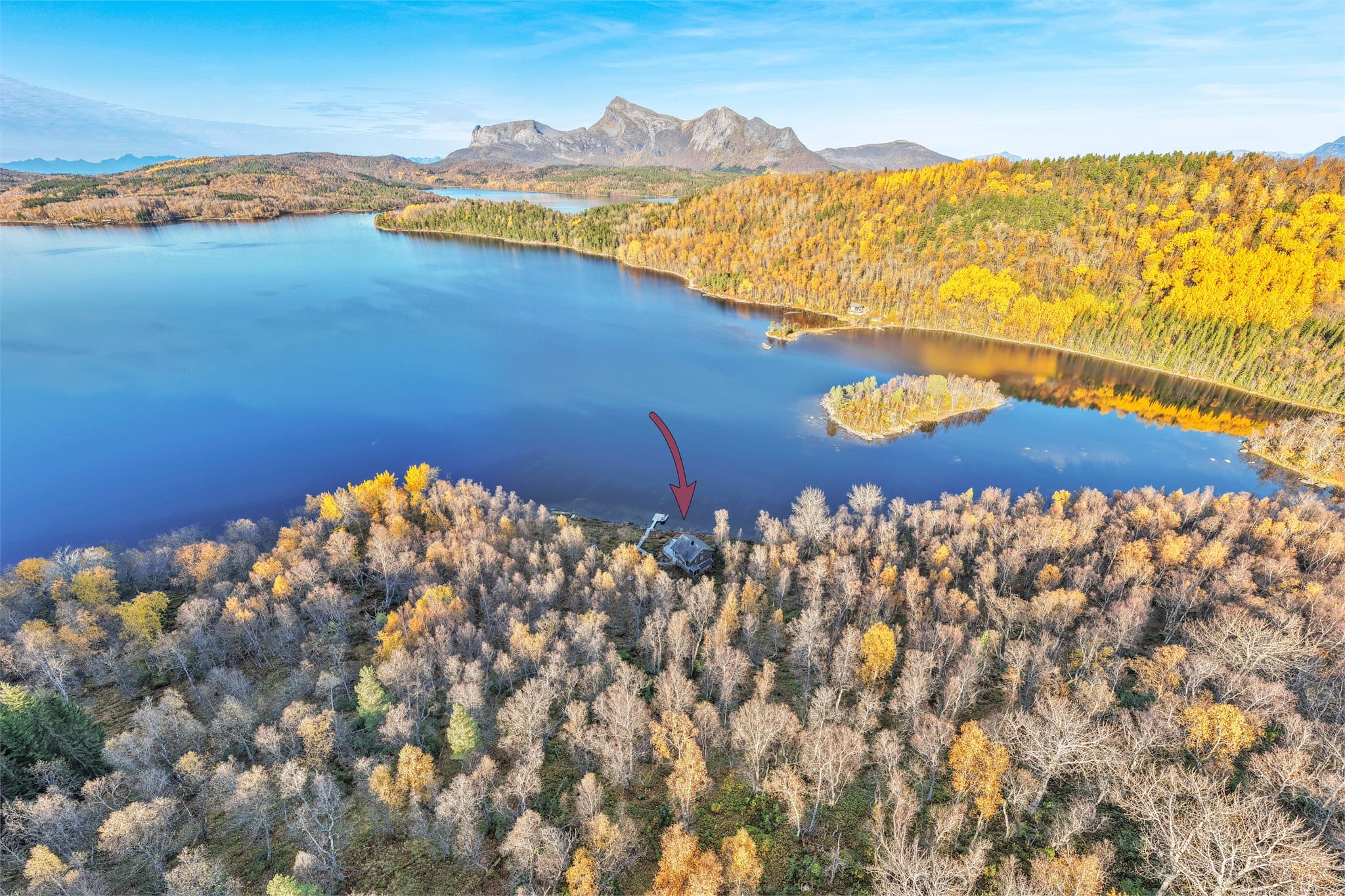 Kilvatnet med omkringliggende høstskog og markerte fjellformasjoner i bakgrunnen.