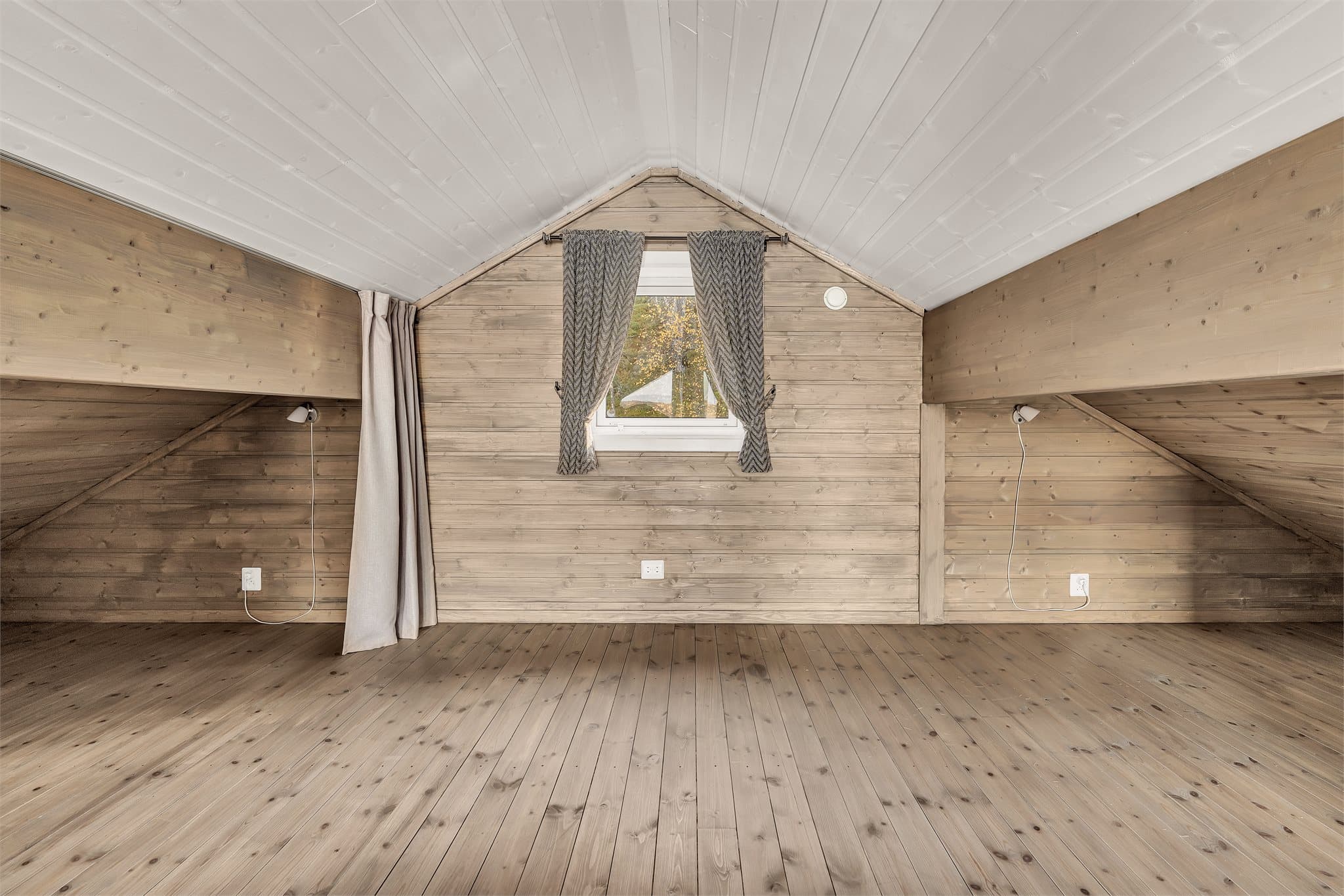 Bakre del av hemsen har vindu i gavlen og leselys montert på veggen.