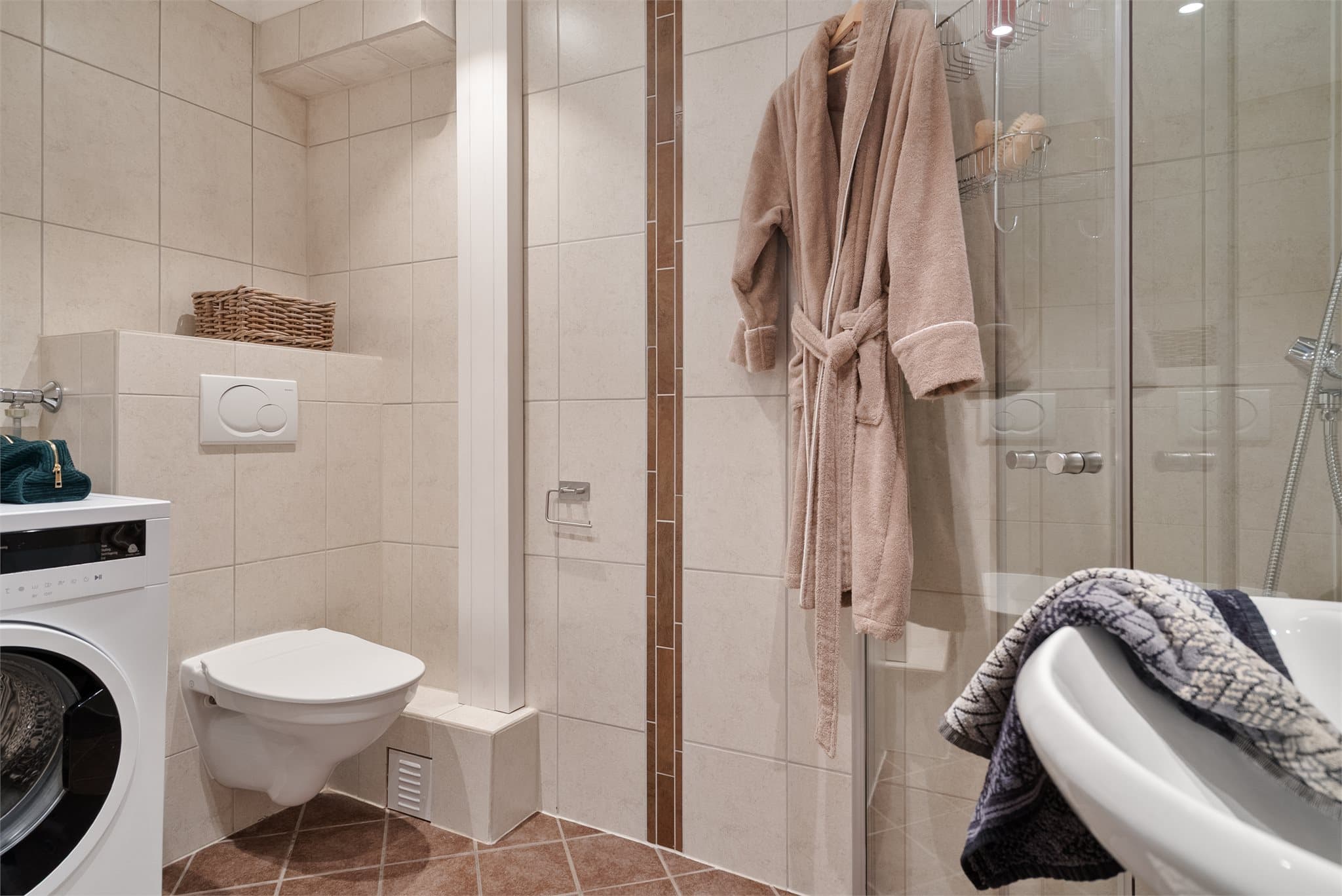Badet er på ca. 3,5 kvm og er utnyttet godt med vegghengt toalett, servant, dusjhjørne og opplegg for vaskemaskin.