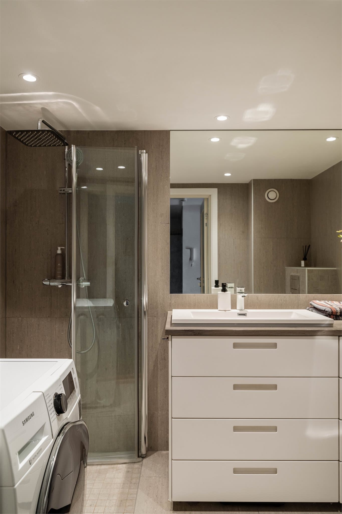 Badet ble pusset opp i 2018 og har flislagte overflater og downlights i taket.