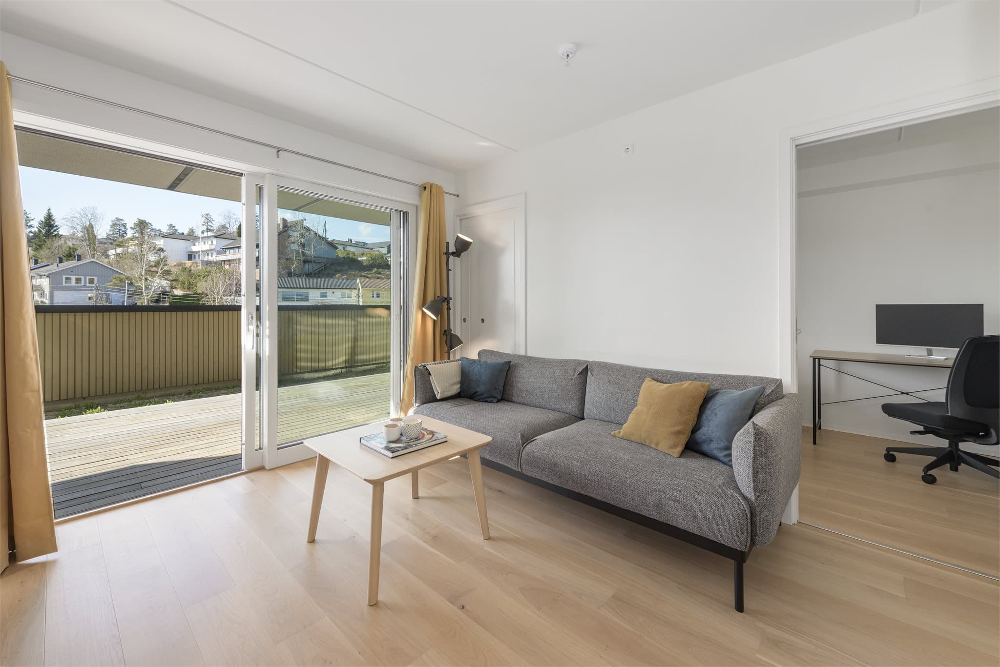 Lys og åpen stue med store vindusflater