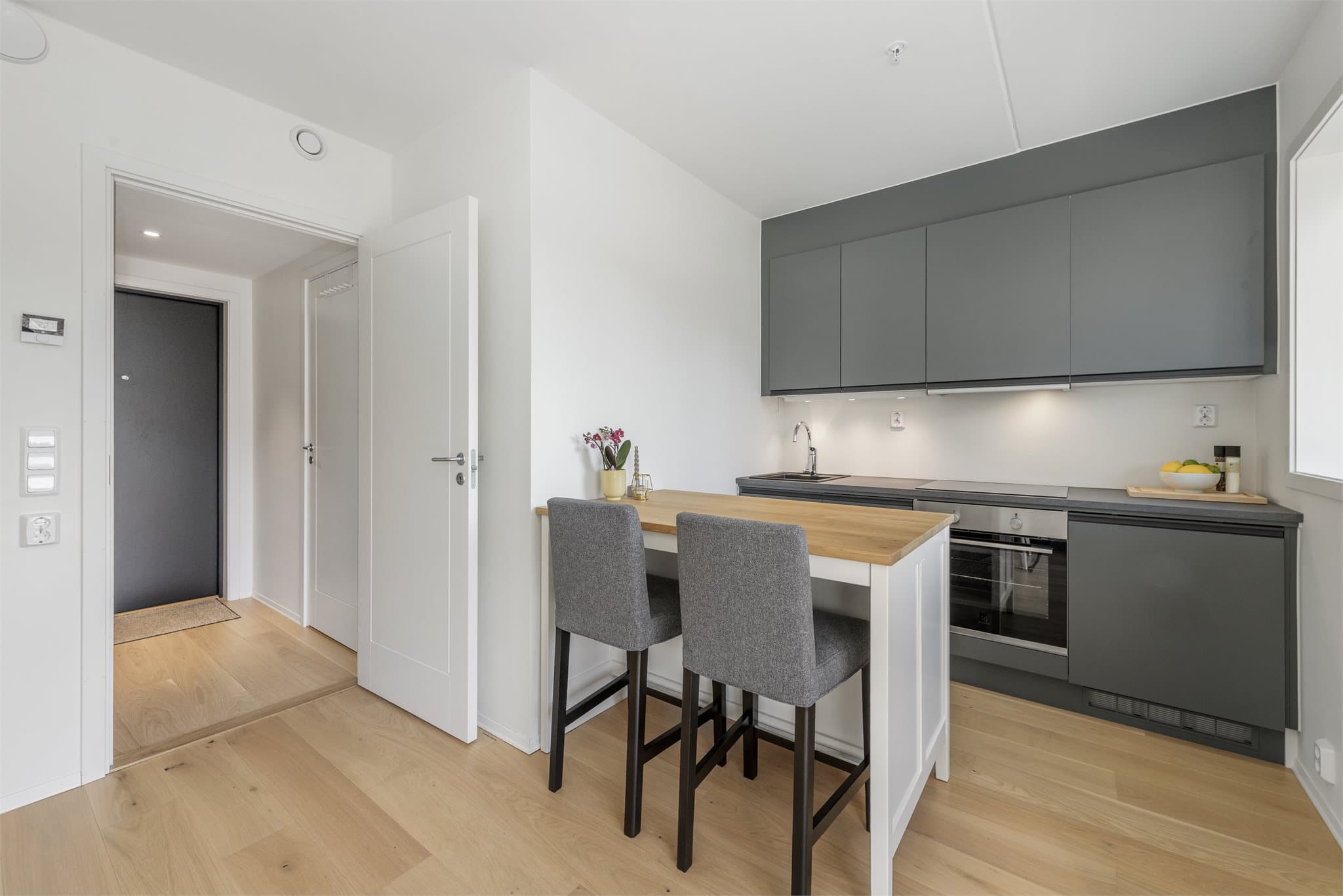 Moderne kjøkken praktisk møblert med spisebord som også gir ekstra benkeplass