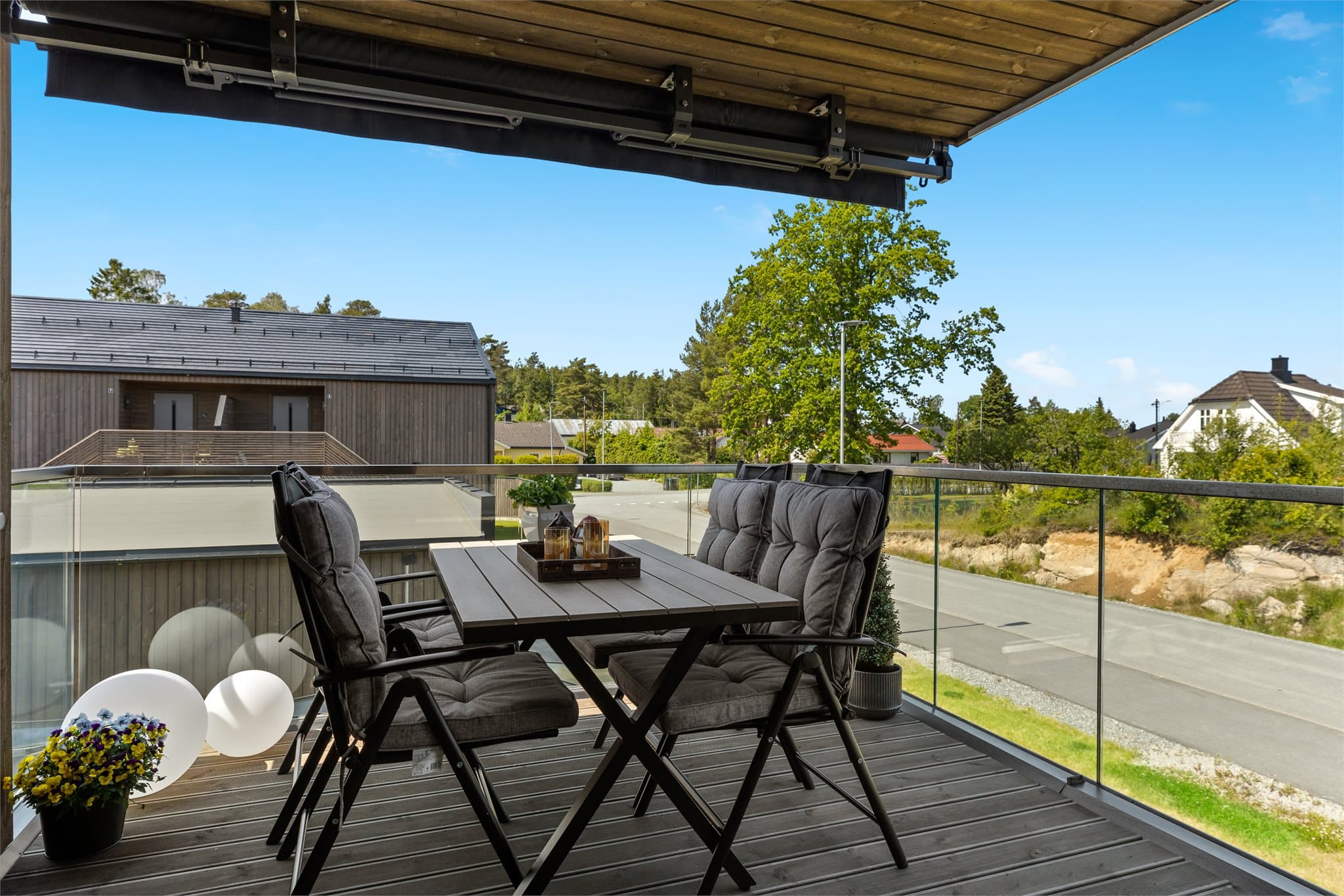 Den vestvendte veranda er delvis overbygd og har markise for ekstra solskjerming.