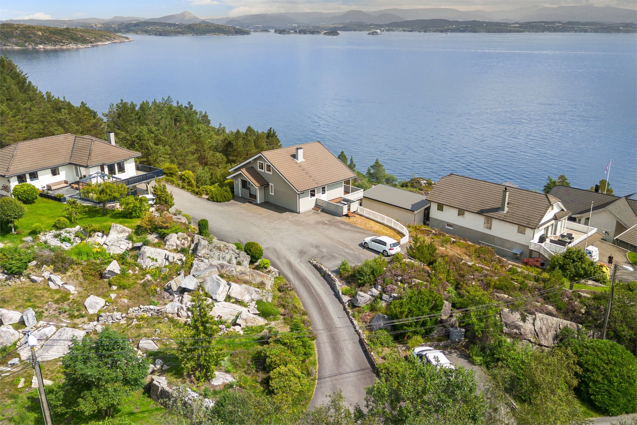 Rikelig med parkering på asfalten på siden av boligen og på plassen rett ved oppkjøringen til boligen