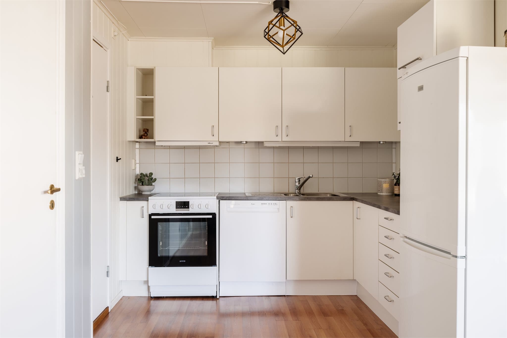 Lys og tidløst kjøkken. Innredningen er ifølge eier fra byggeåret og har glatte fronter og benkeplate i laminat.
