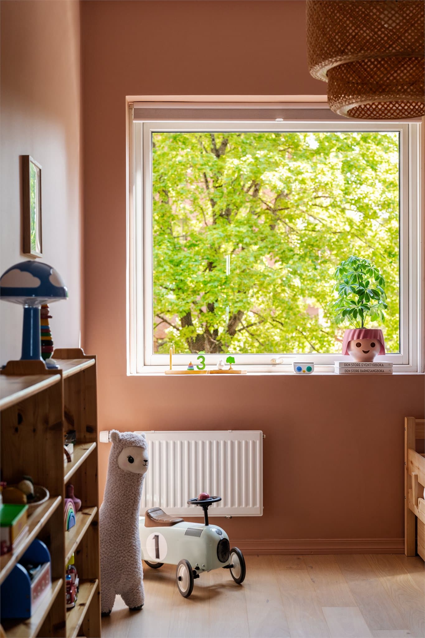 Rommet er malt i en fresh farge som skaper en flott kontrast til de grønne omgivelsene utenfor, og gir en frodig og innbydende atmosfære.