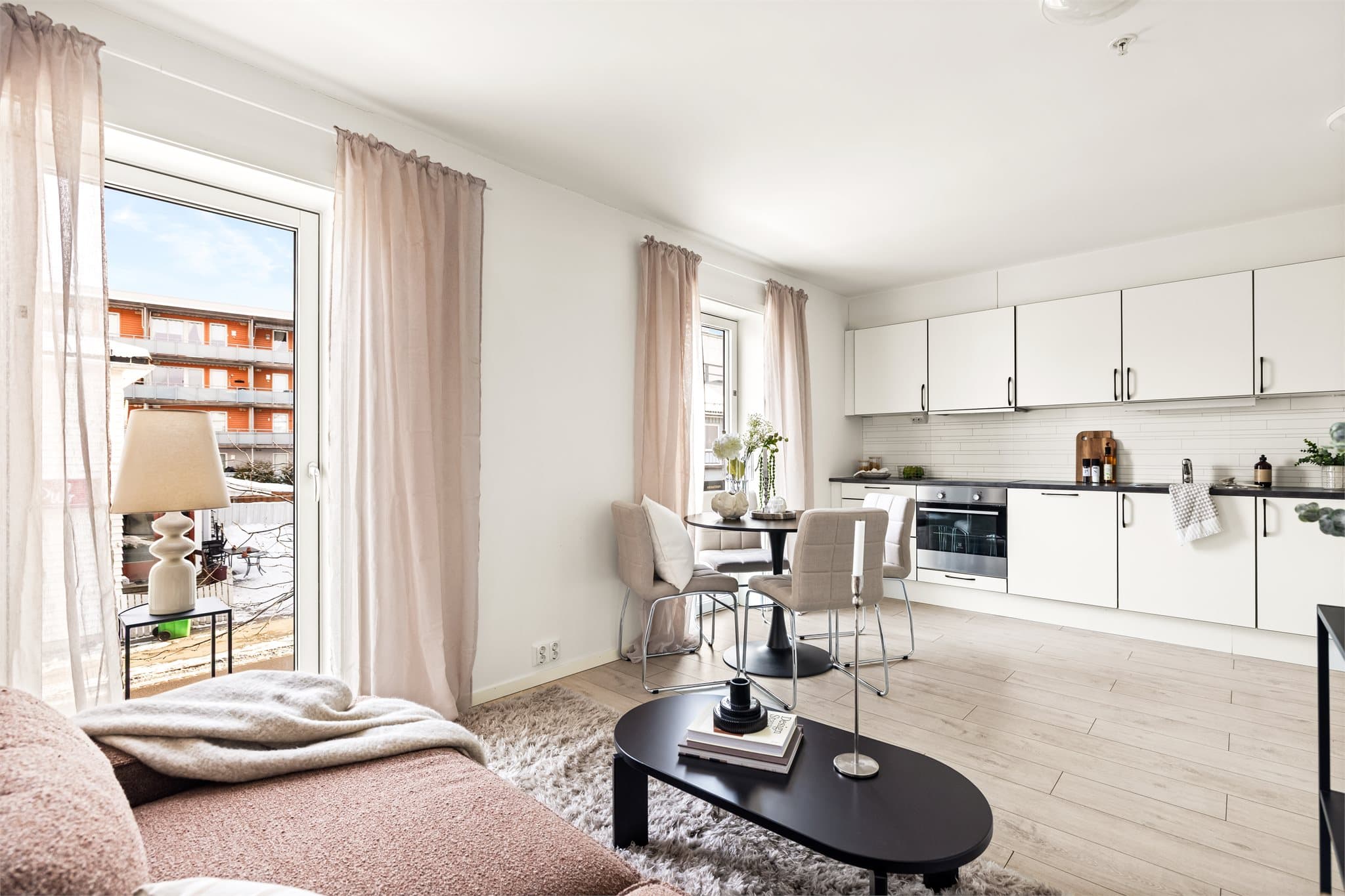 Den åpne løsningen mellom stue og kjøkken skaper en sosial og luftig atmosfære.