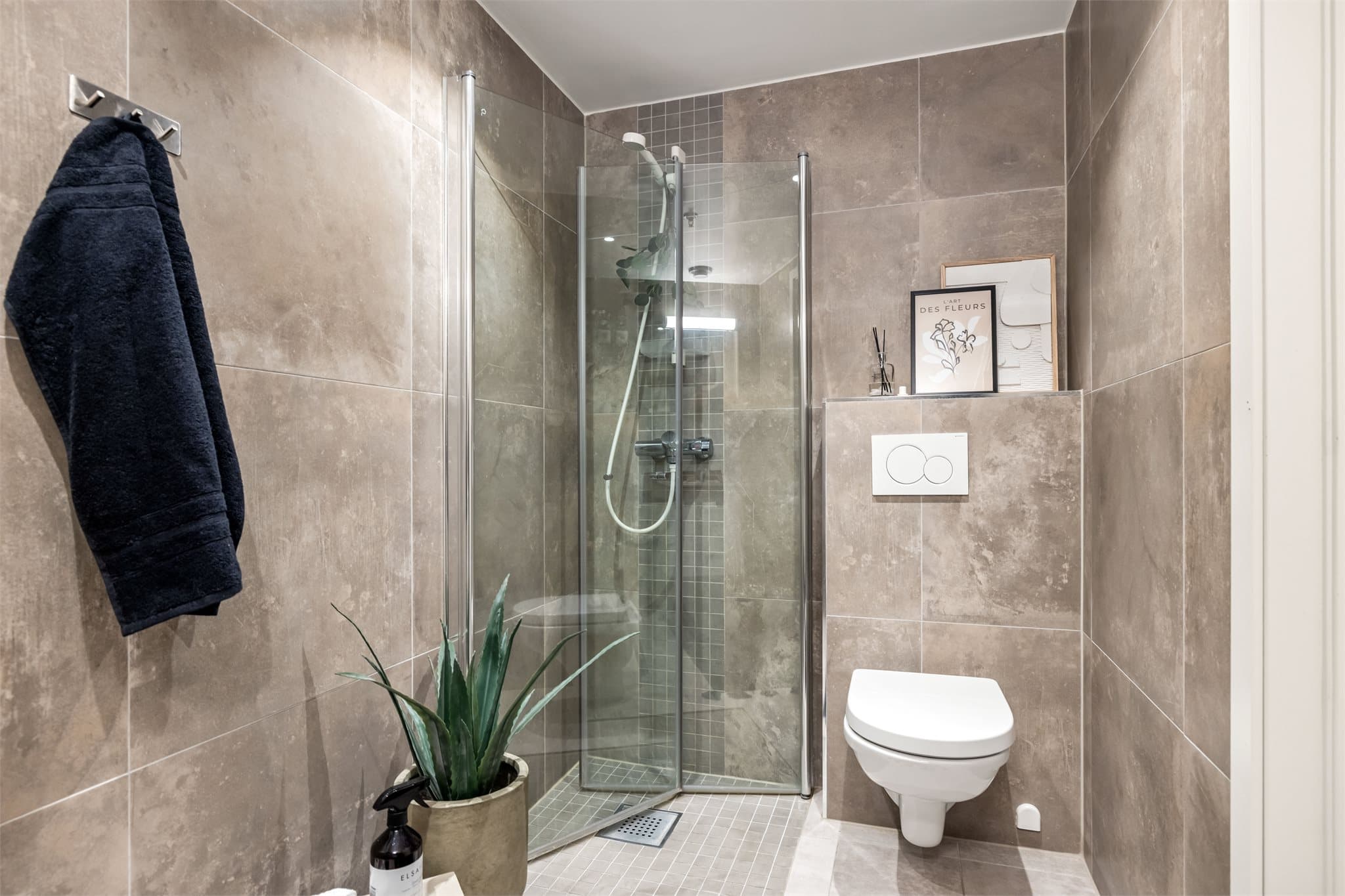 Her finnes også et vegghengt toalett og en dusjnisje med innfellbare vegger.