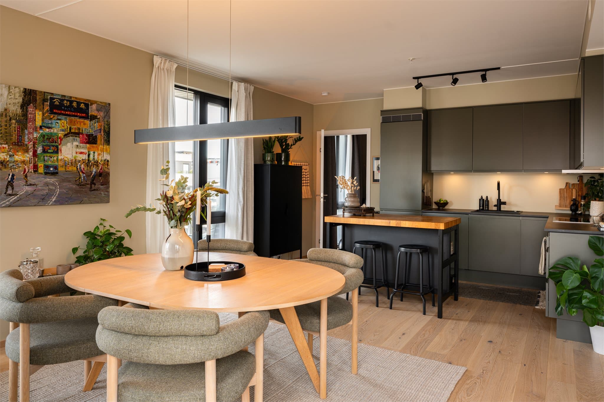 Den åpne planløsningen gir god plass til både en romslig sofagruppe og et stort spisebord, med en naturlig overgang til kjøkkenet.