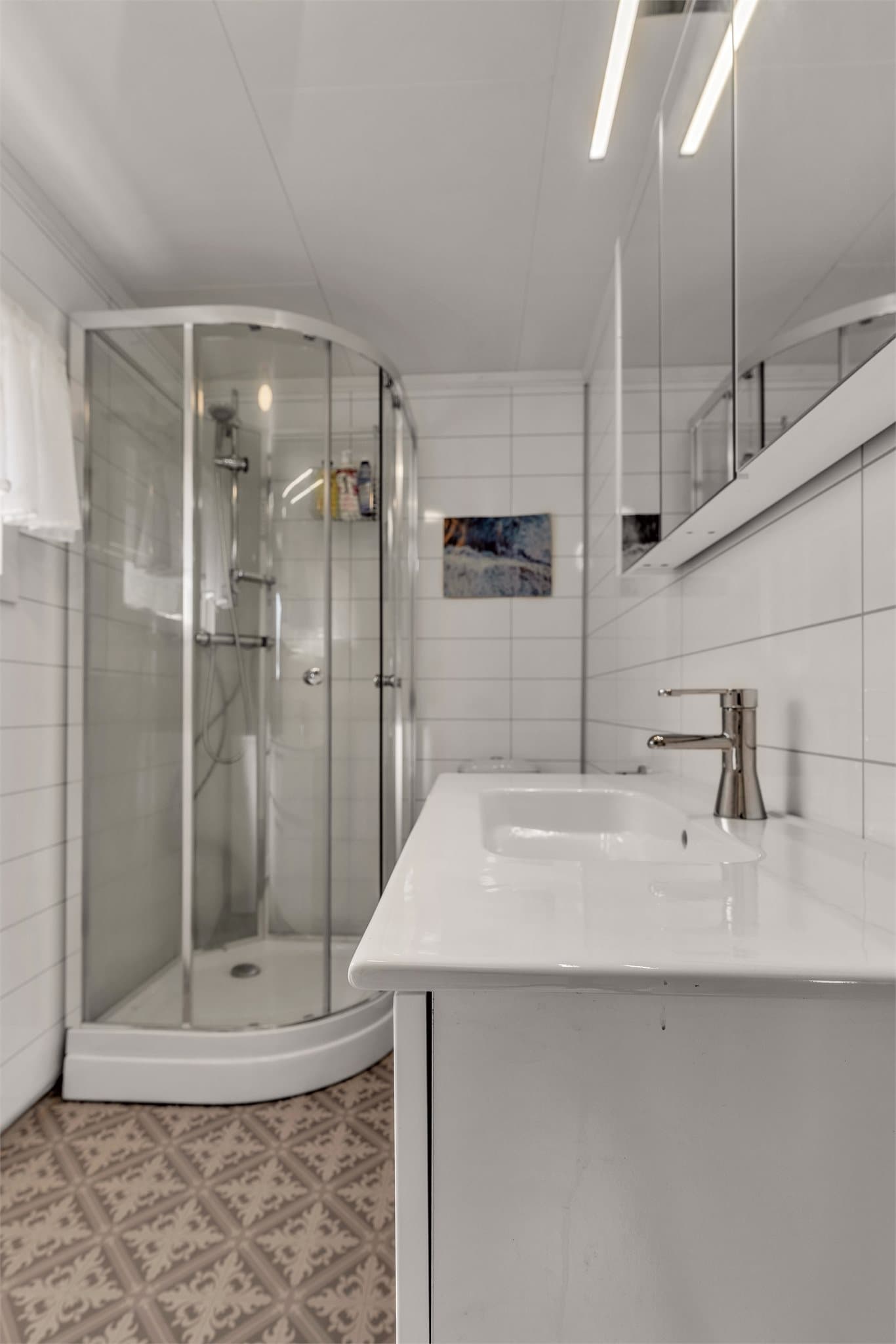 Badet i første etasje har dusjkabinett og servant med underskap.