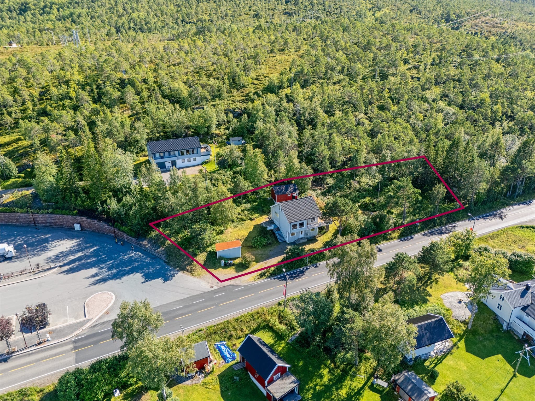 En innholdsrik eiendom med enebolig, garasje og uthus.