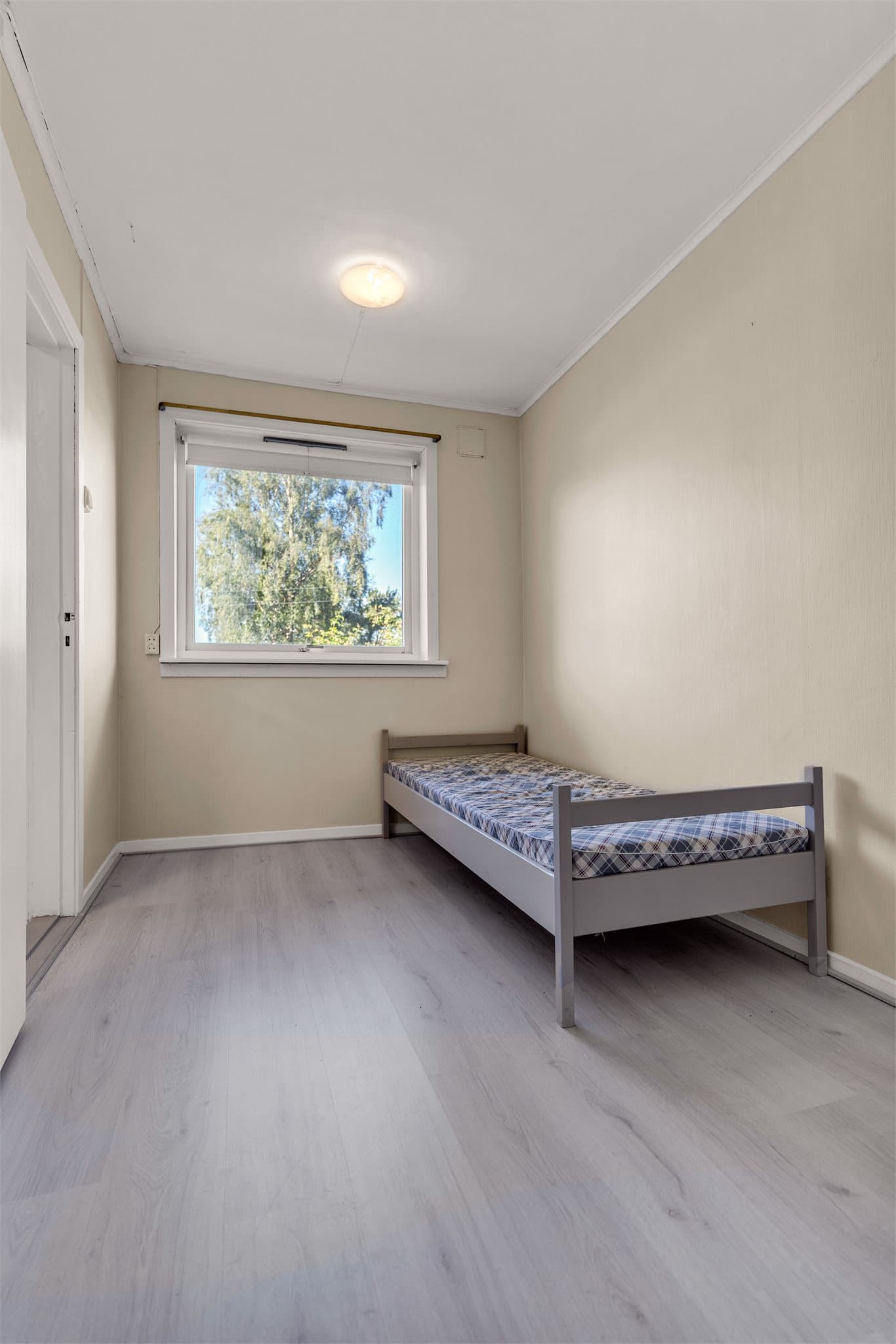 Soverommet i underetasjen har laminatgulv og lyse vegger.