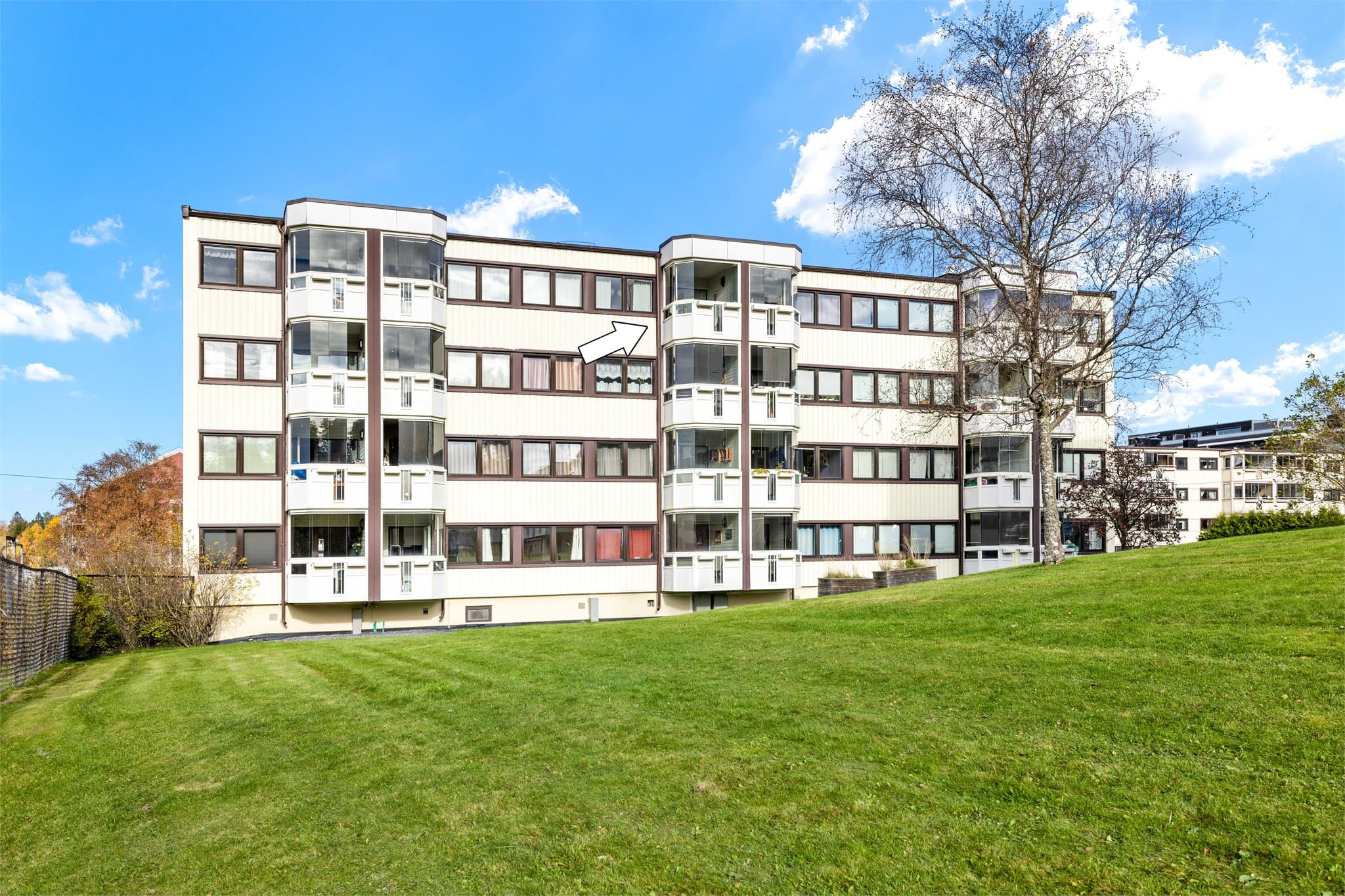 Bygningen er en boligblokk fra 1964, omgitt av store, grønne fellesarealer.