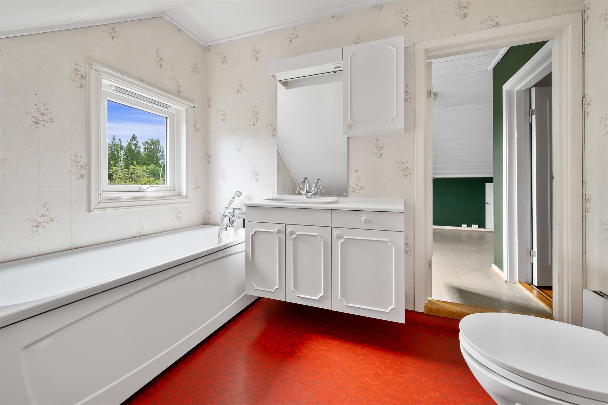 Badet er innredet med klosett, servantinnredning og badekar.