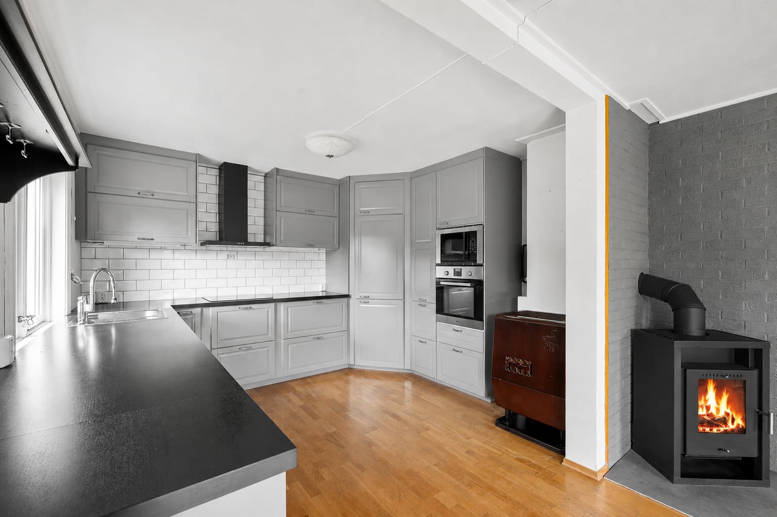 Kjøkkeninnredning fra IKEA med grå, profilerte fronter og laminat benkeplate. Integrerte hvitevarer som platetopp, oppvaskmaskin, stekeovn, micro og kombiskap kjøl/frys medfølger salget.