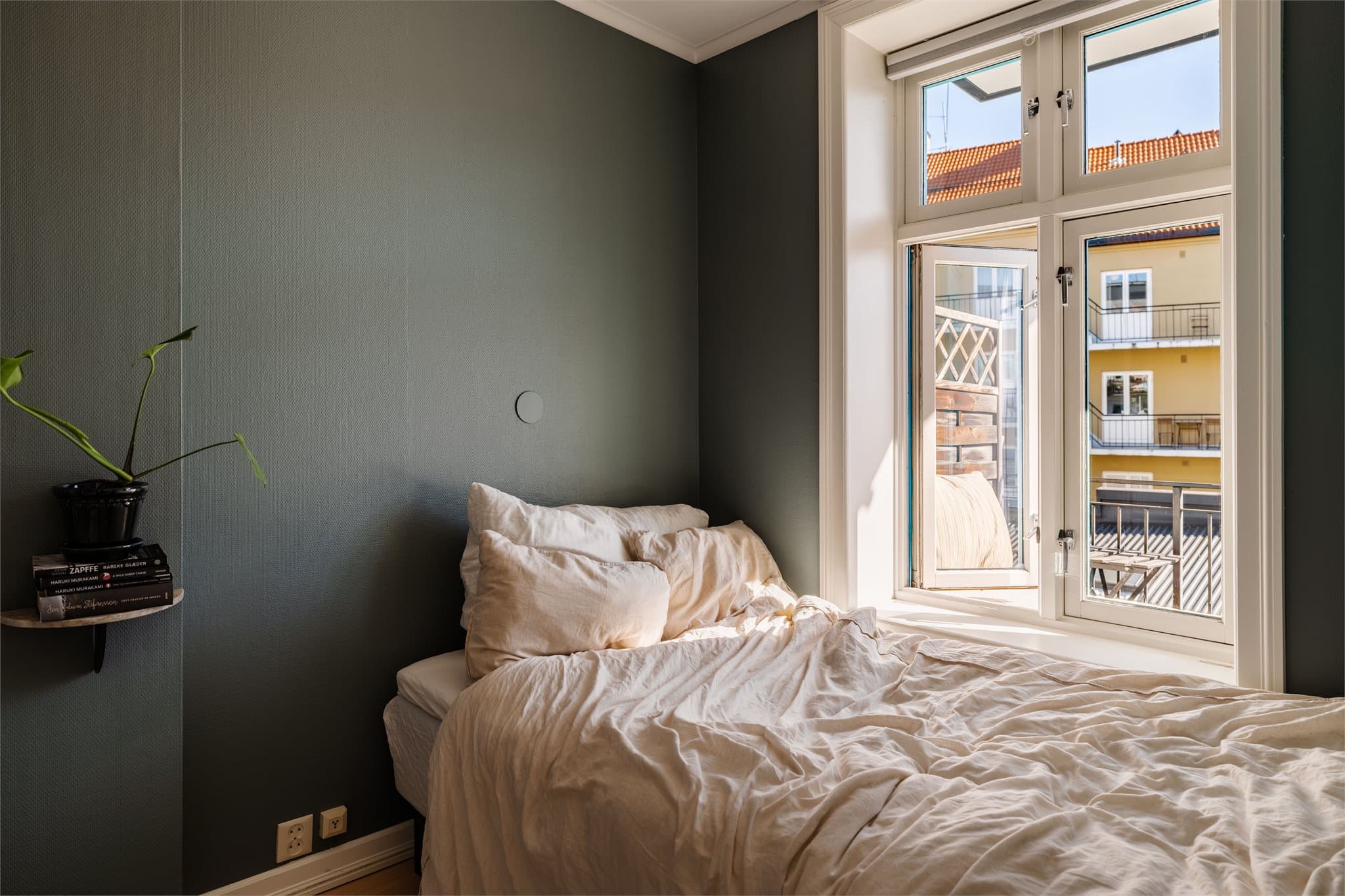 Soverommet er innbydende med plass til dobbeltseng og nattbord. Store vindusflater slipper inn godt med dagslys, og de mørke veggene skaper en fin kontrast til de lyse detaljene.