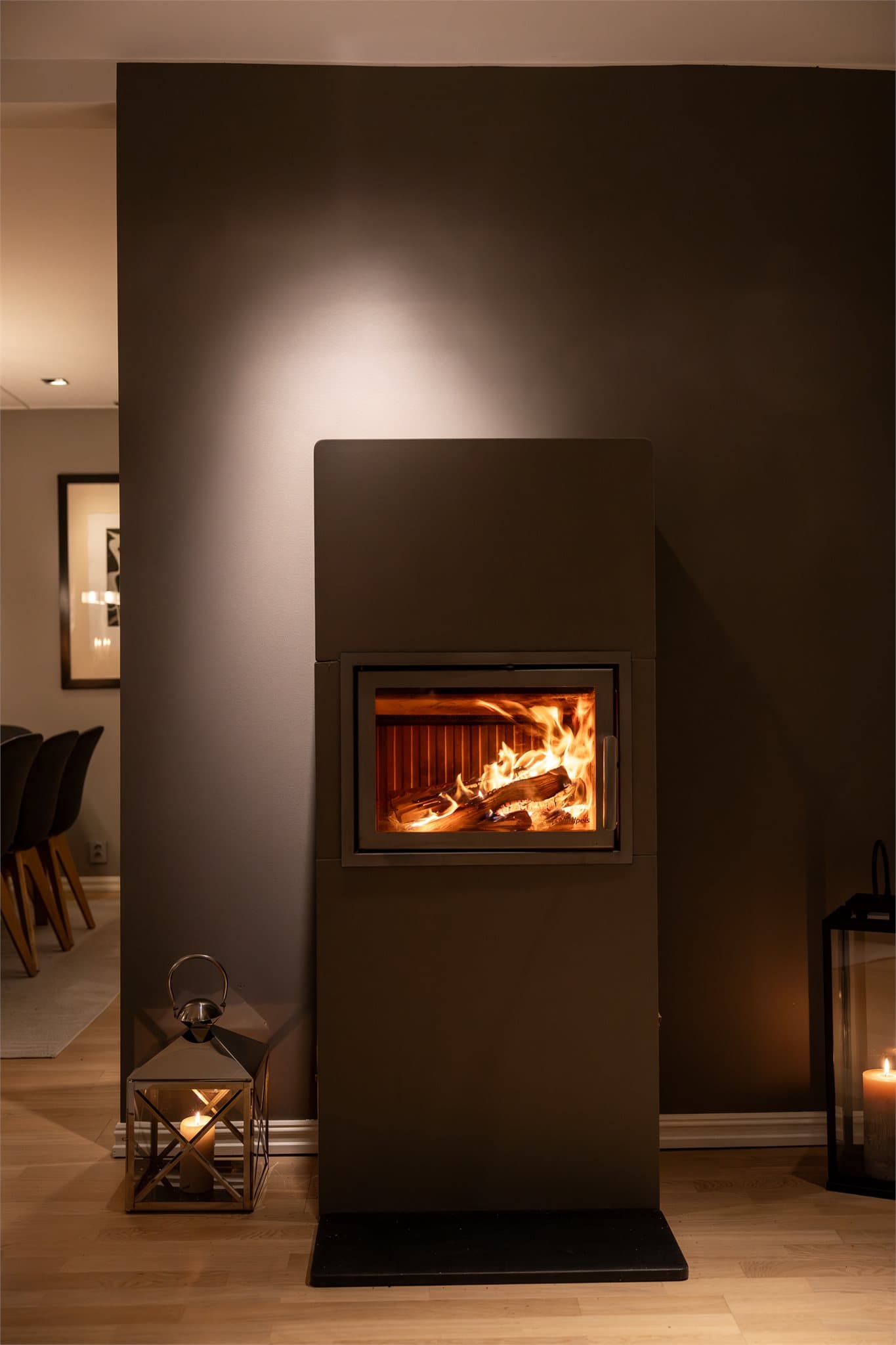 Midt i rommet står en peisovn med glassdør, perfekt for å skape en koselig atmosfære på kjølige kvelder.