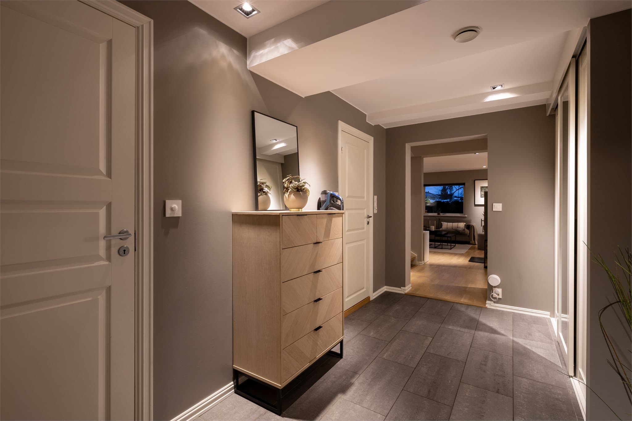 Entréen i boligen er utstyrt med et stort garderobeskap som gir god plass til yttertøy og andre tekstiler. Fra gangen er det direkte tilgang til walk-in garderobe, bad og vaskerom, som gir en svært praktisk løsning i hverdagen.