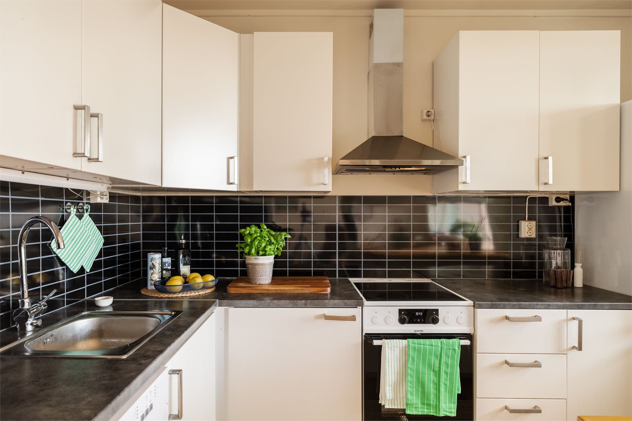 Kjøkkeninnredning med glatte fronter, laminat benkeplate og oppvaskmaskin.