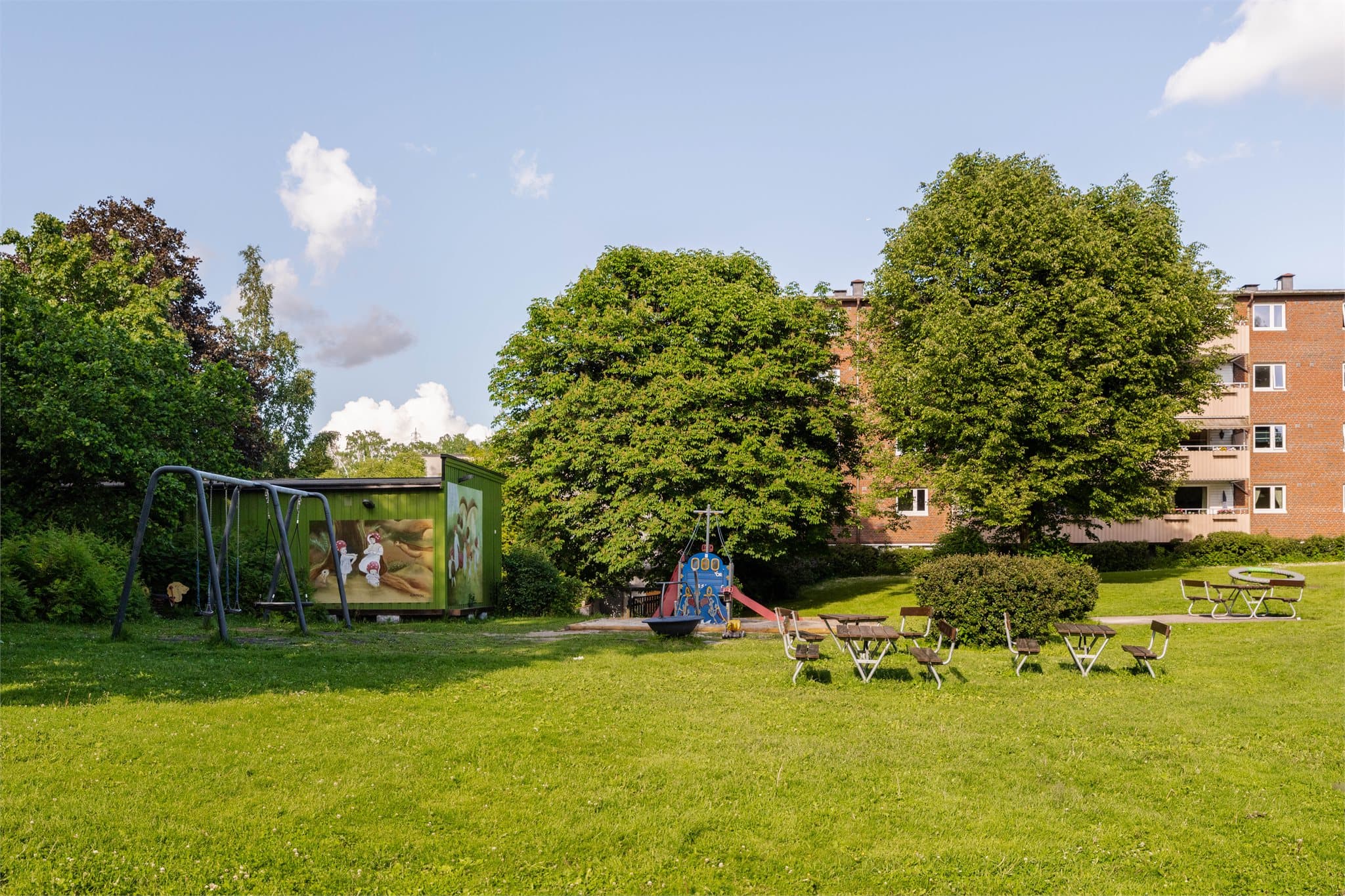 Store, grønne fellesarealer med lekeplass og sittegrupper til glede for beboerne.