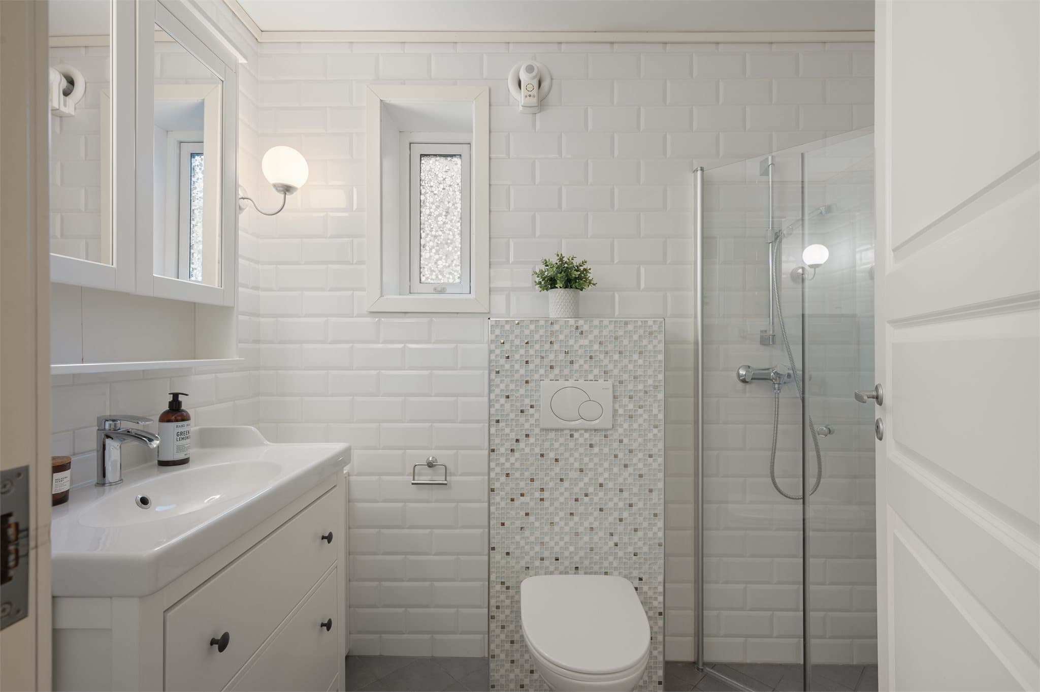 - Badet er innredet med heldekkende servant, speilskap, vegghengt toalett, dusjhjørne og opplegg til vaskemaskin -