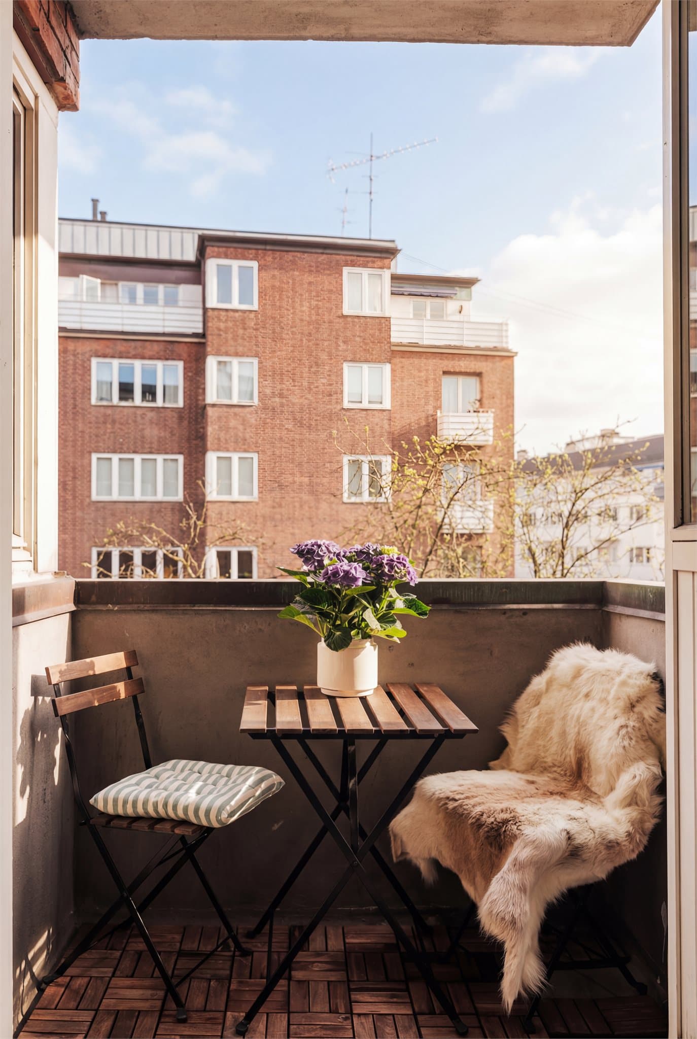 Koselig balkong høyt og fritt med tidlig formiddagssol. Bildet er redigert med AI for å illustrere forholdene på solskinnsdager.