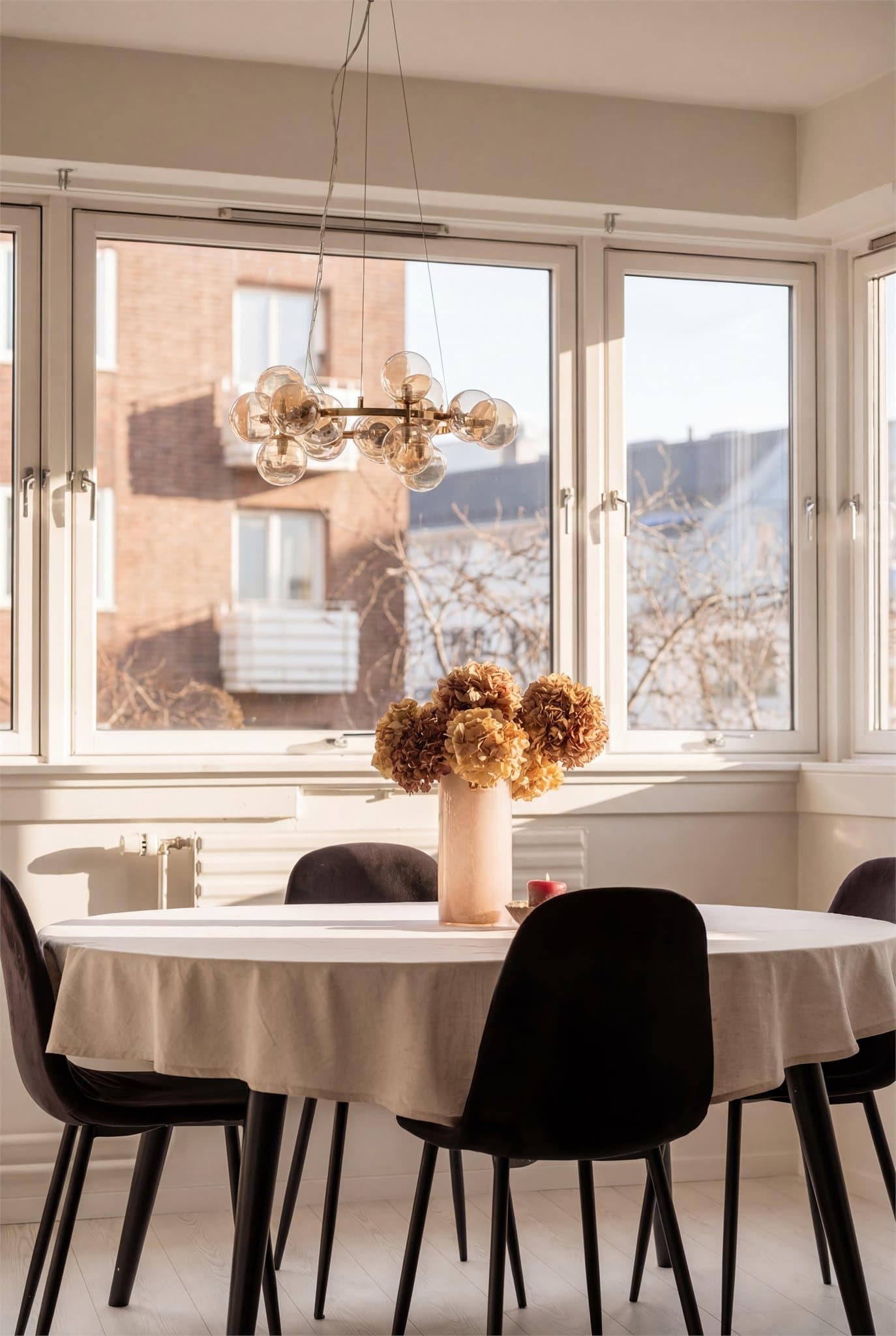 Ved kjøkkenet har du god plass til en hyggelig sosial sone ved lyse vinduer. Bildet er AI redigert for å illustrere lysforholdene i leiligheten på solskinnsdager.