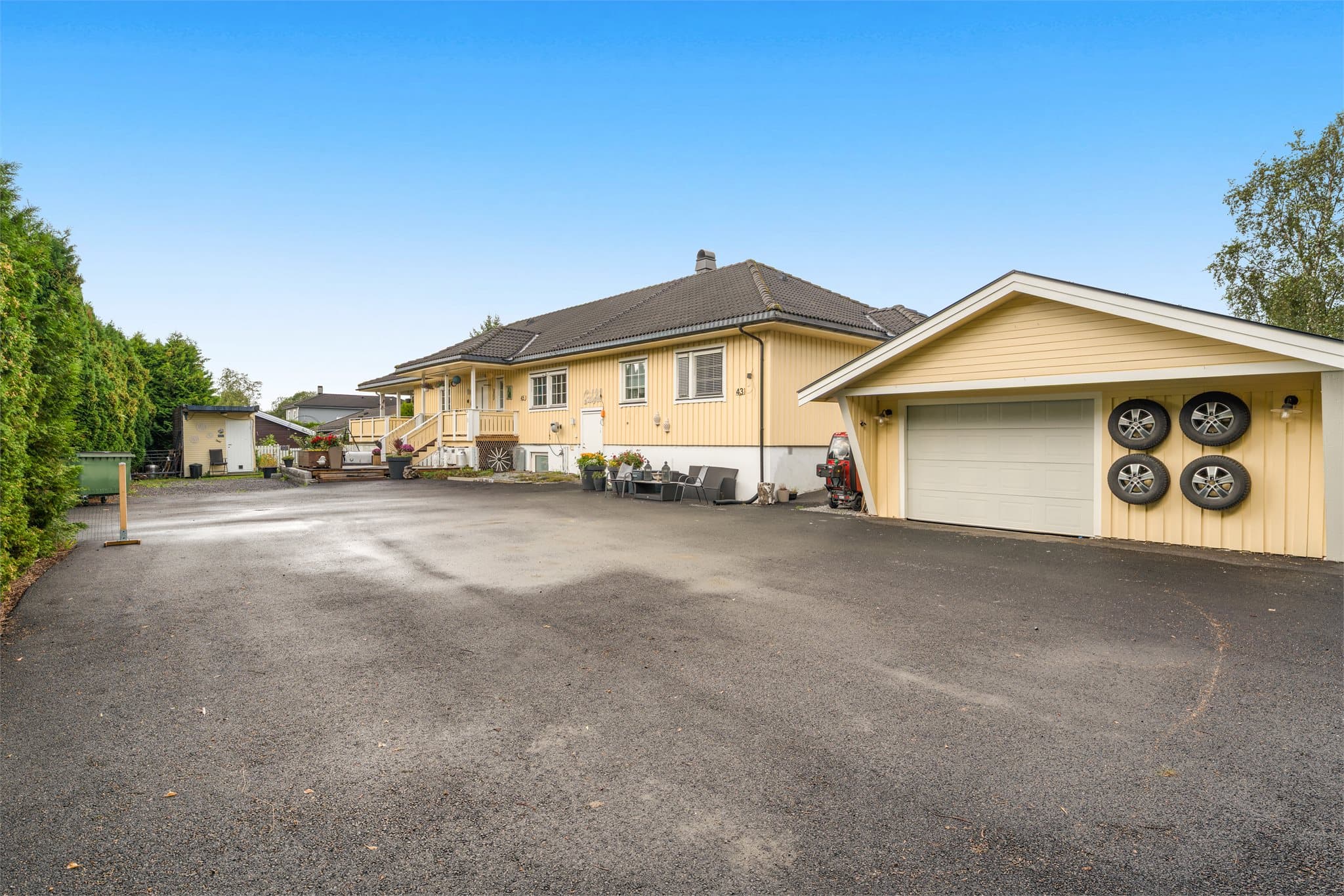 Stor asfaltert innkjørsel og garasje.