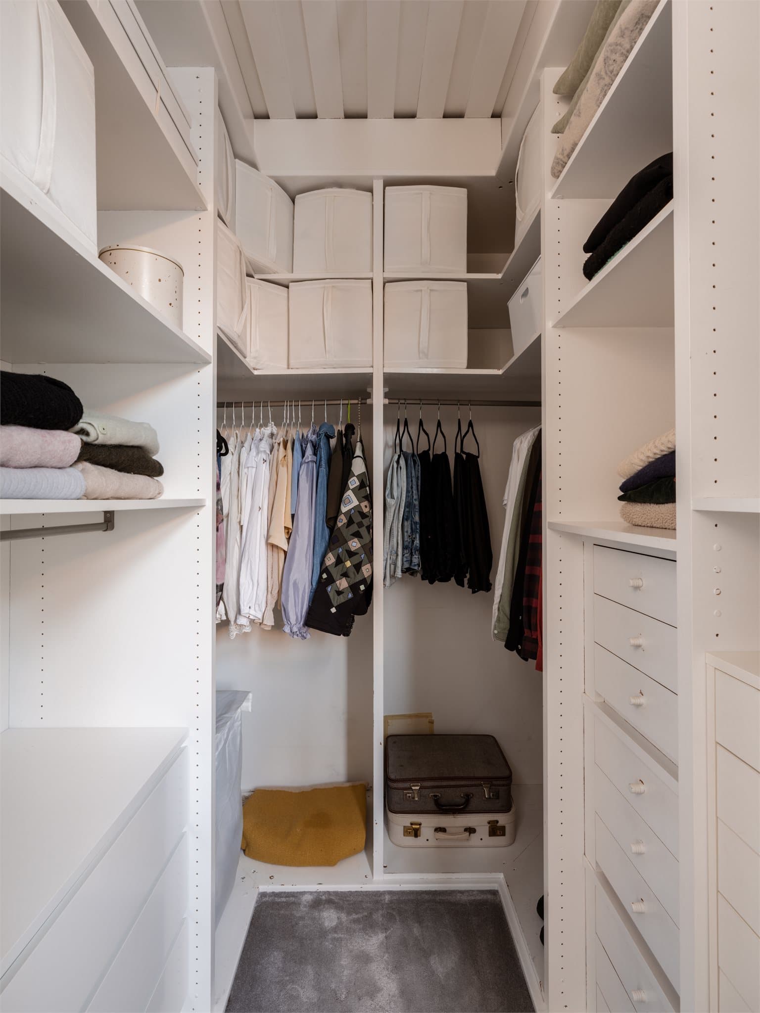 Garderobeløsningen er innredet med hyller, skuffer og oppheng for effektiv organisering.