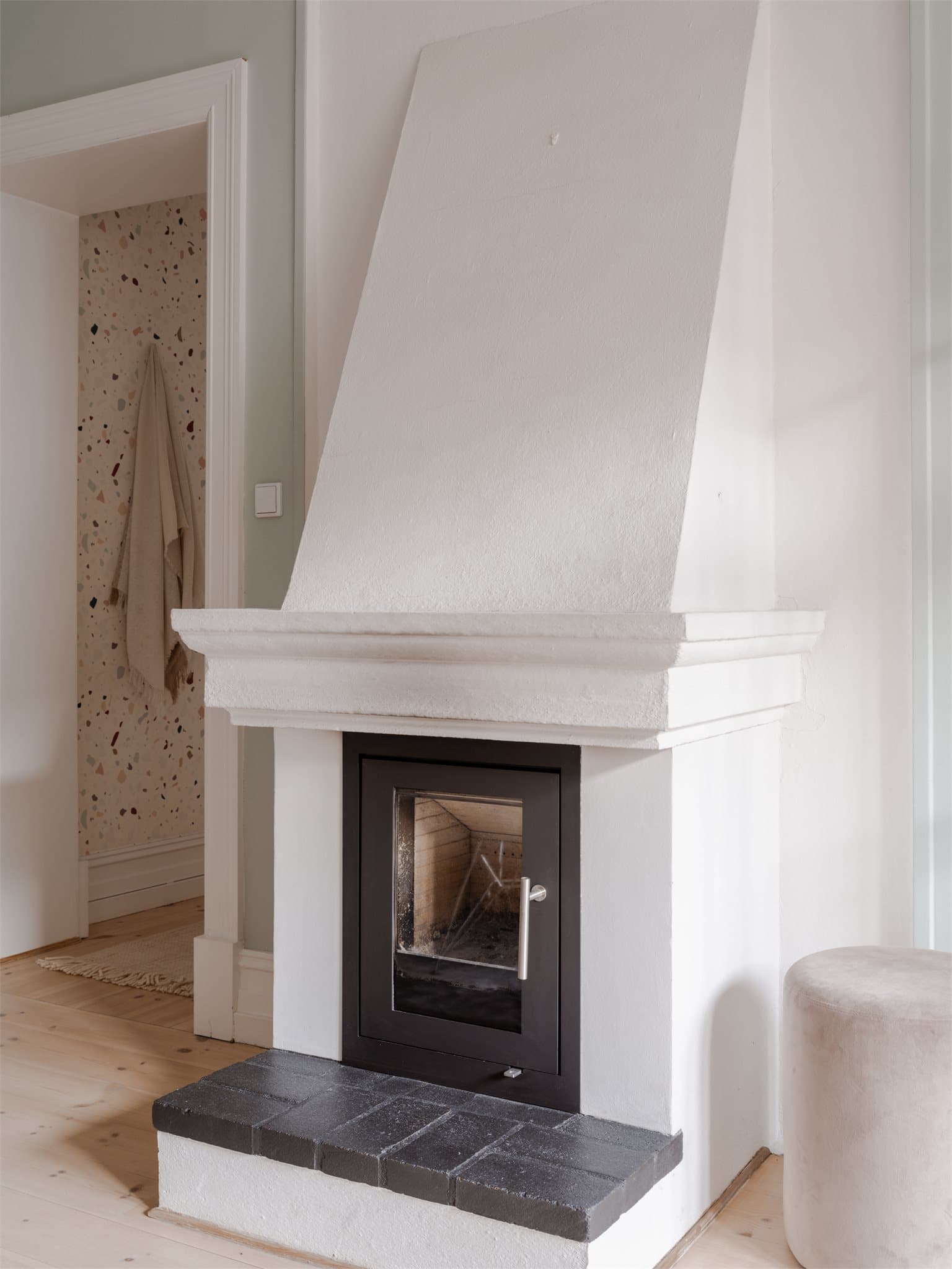 Peisen har et rent og moderne uttrykk som komplementerer rommets klassiske stil.