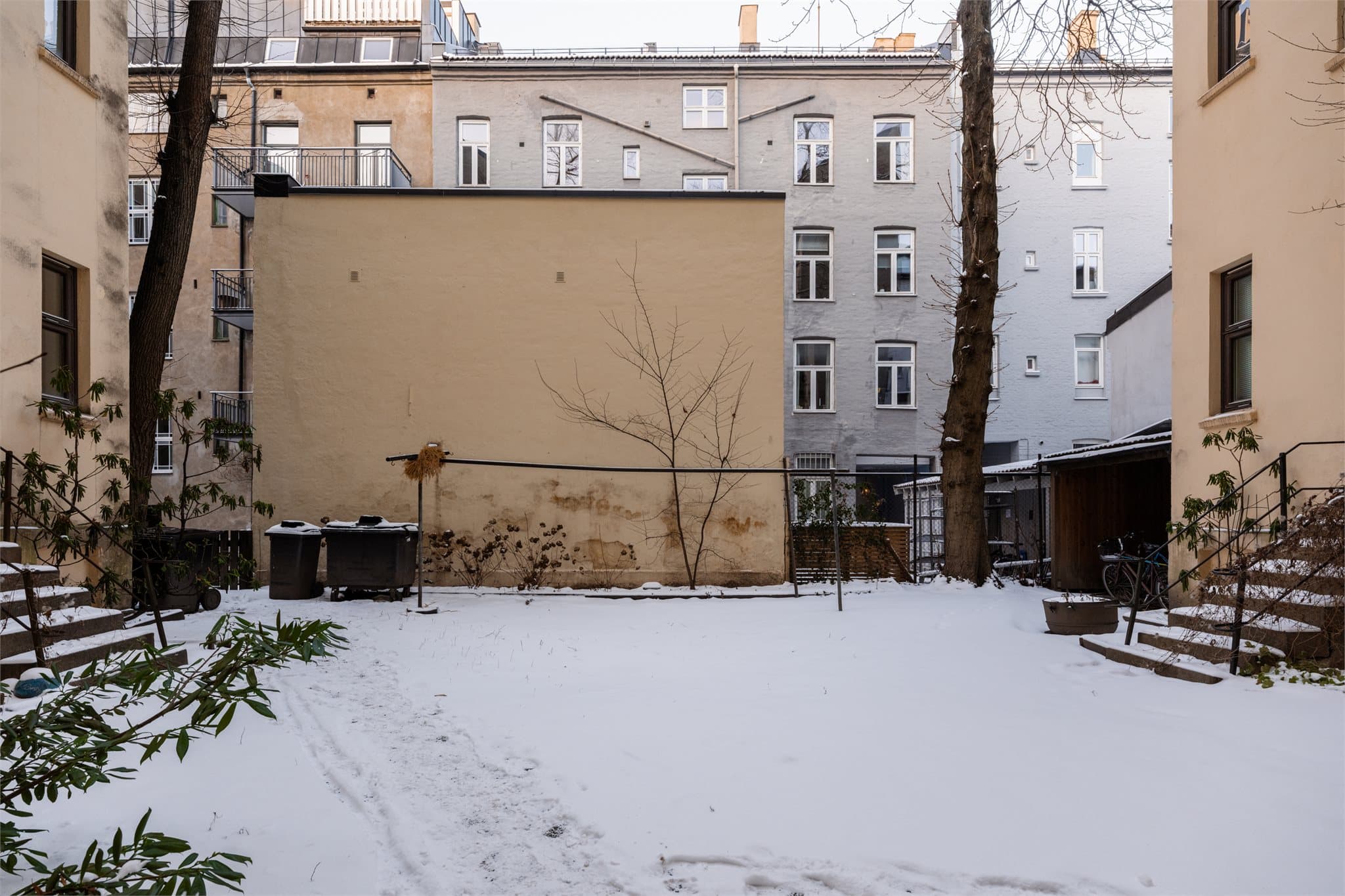 Pen og hyggelig inngjerdet forhage beplantet med plen, busker og trær. Opparbeidet bakgård med bl.a. sykkelparkering.