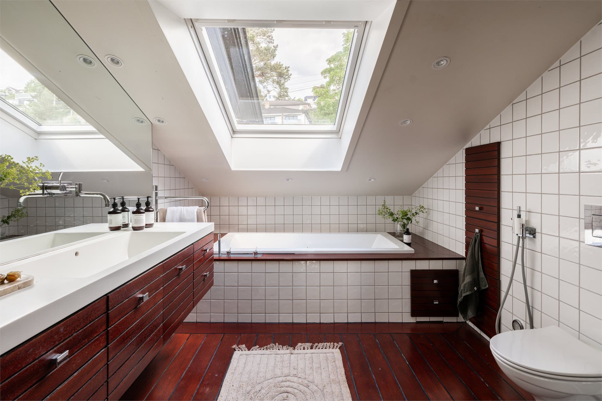 Det store badet fremstår som delikat og innholdsrikt med særpreget design. Badekar, separat dusjsone og innredning med god oppbevaringsplass gir en komfortabel og spa-inspirert følelse.