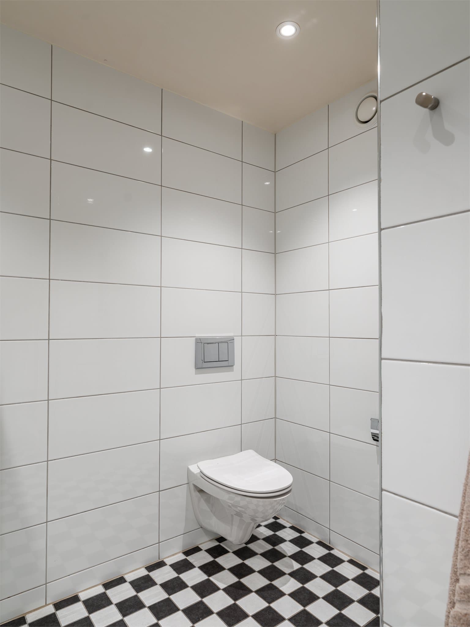 Badet er utstyrt med vegghengt toalett med innebygget sisterne.
