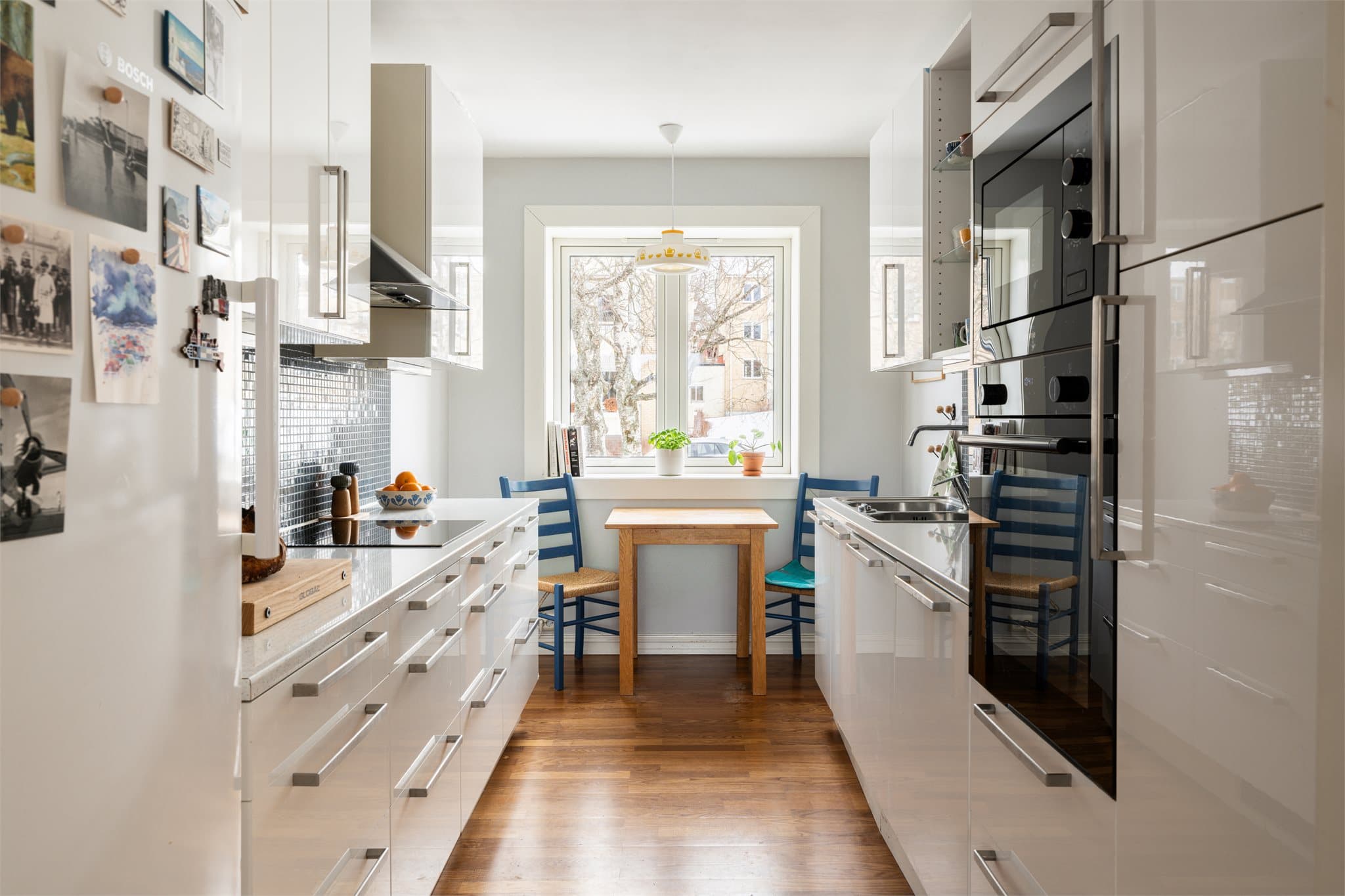 Kjøkkenet har en funksjonell utforming med glatte, hvite fronter og integrerte hvitevarer.