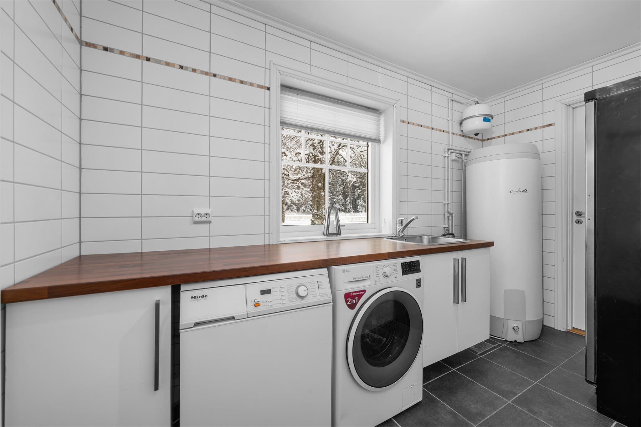 Innenfor kjøkkenet er det et praktisk vaskerom med egen inngang.