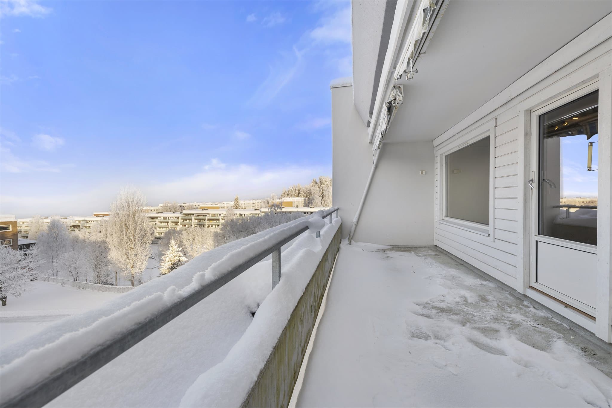 Balkong med utsyn mot nærområdet og felles grøntarealer.