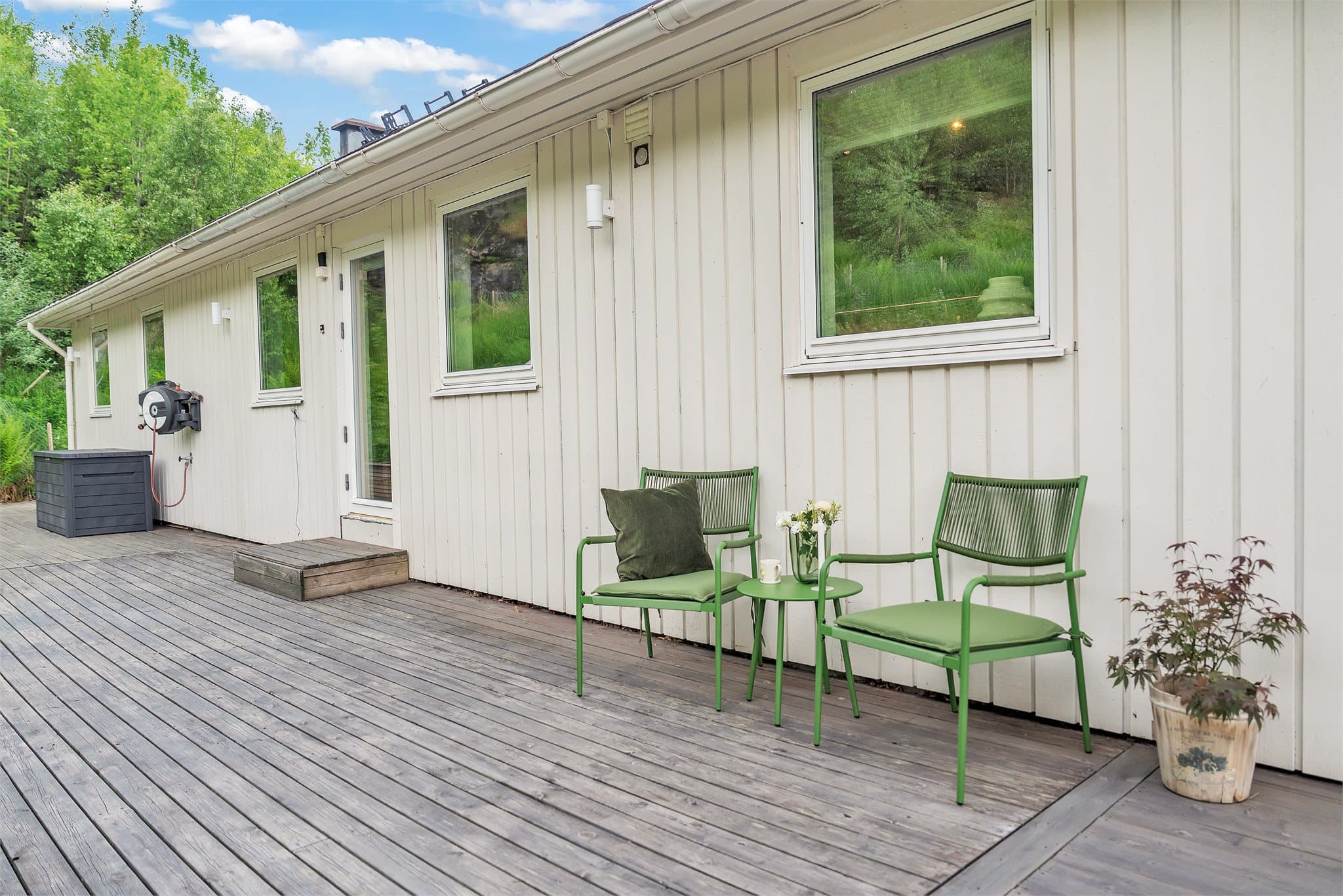 De store terrasseområdene er bygget i trevirke og omkranser store deler av boligen.