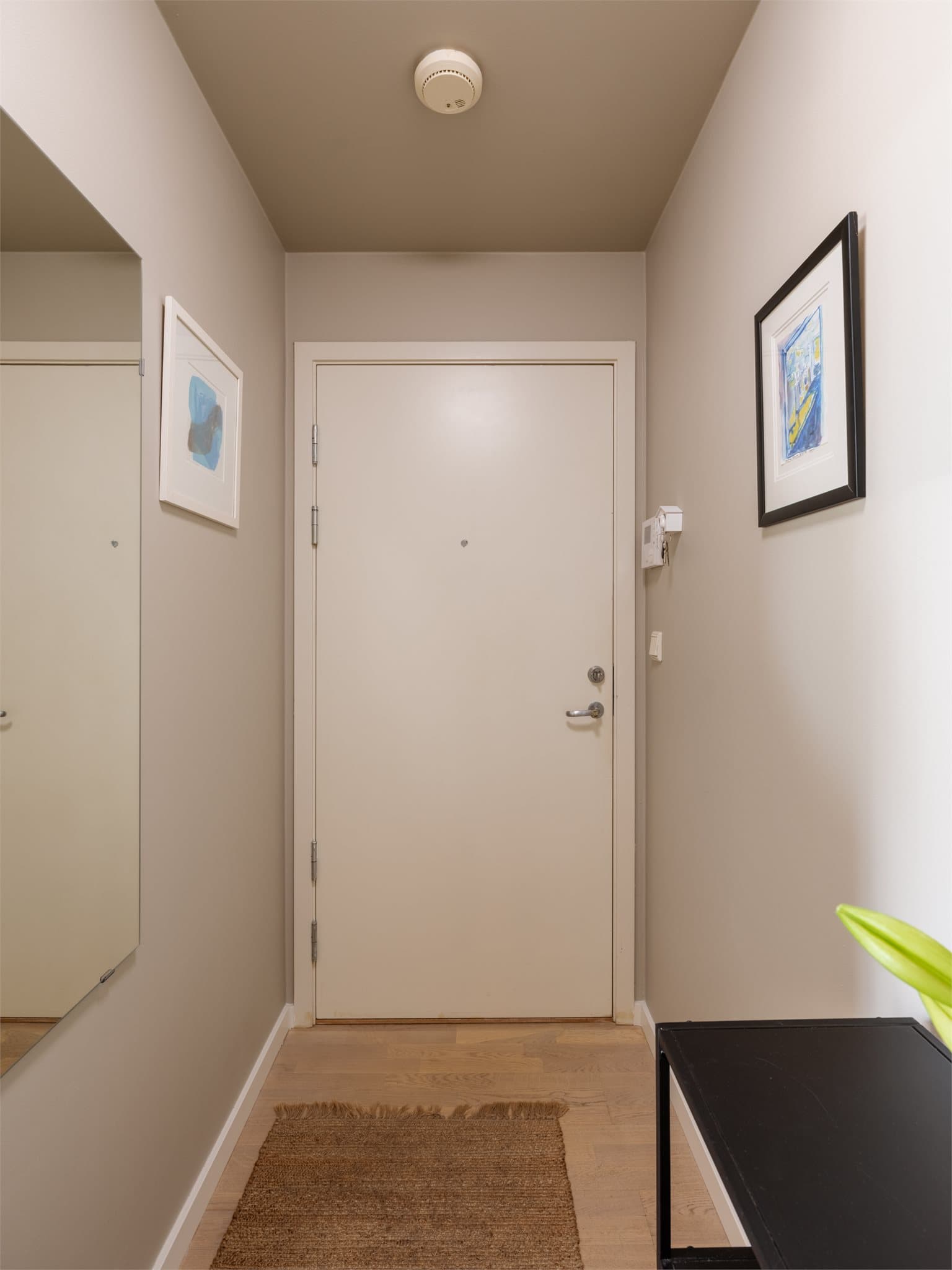 Leiligheten har en innbydende entré som fungerer som en egen sone, slik at du kan ta imot gjester uten at de havner rett inn i stuen.
