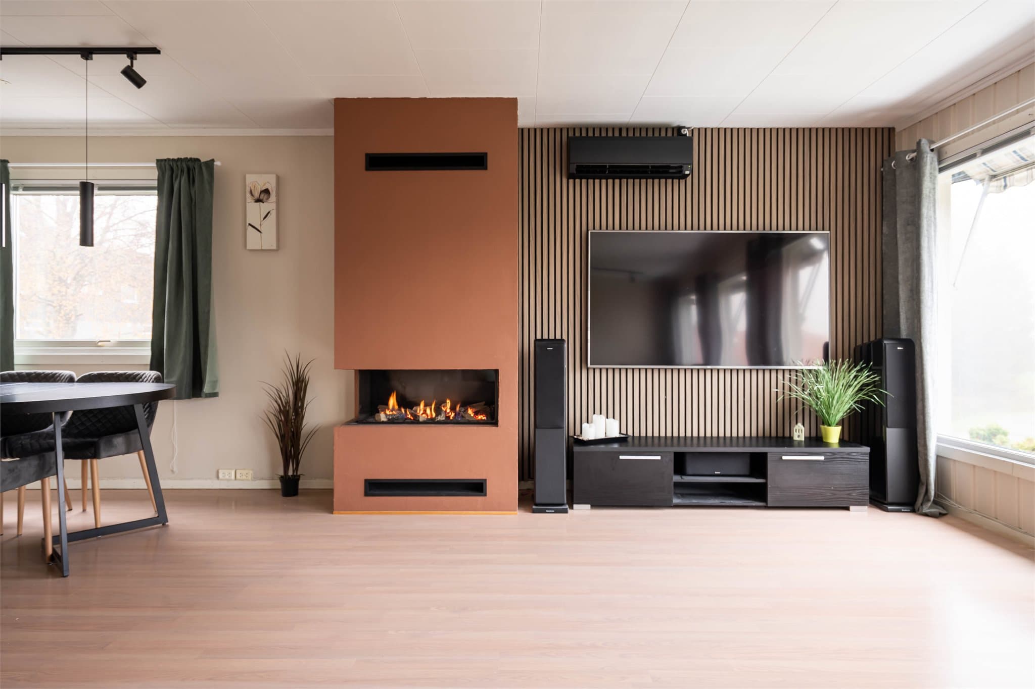 Denne bidrar til en lun og hyggelig atmosfære, spesielt på kjølige høst- og vinterkvelder. Veggen med spilepanel gir også stuen et moderne preg.