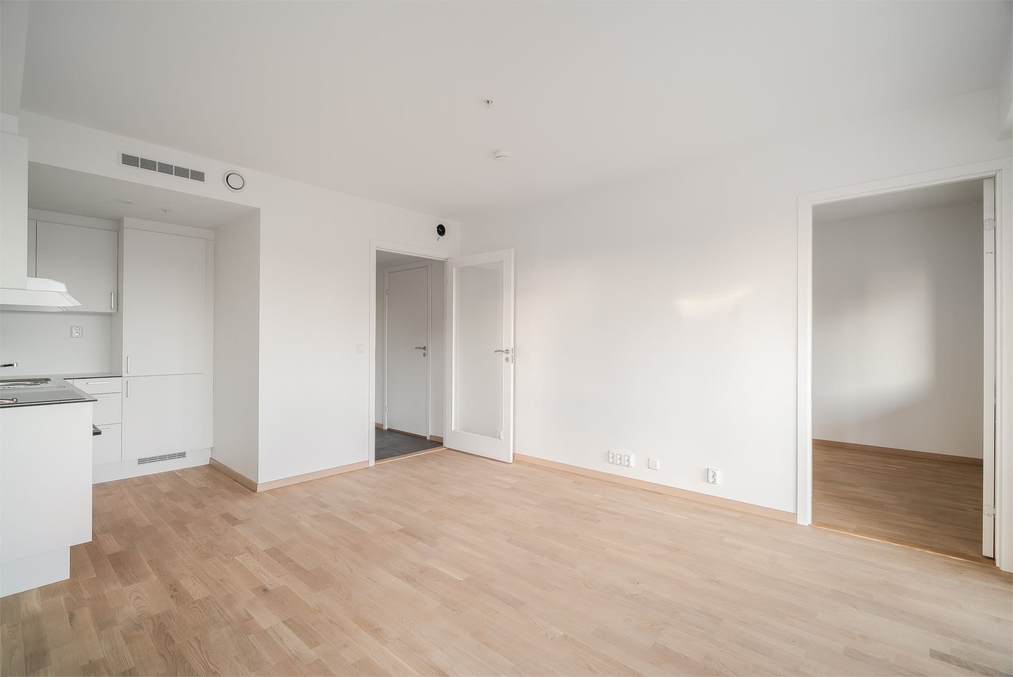 Stue og kjøkken er samlet i en lys og åpen løsning som skaper en romslig følelse.