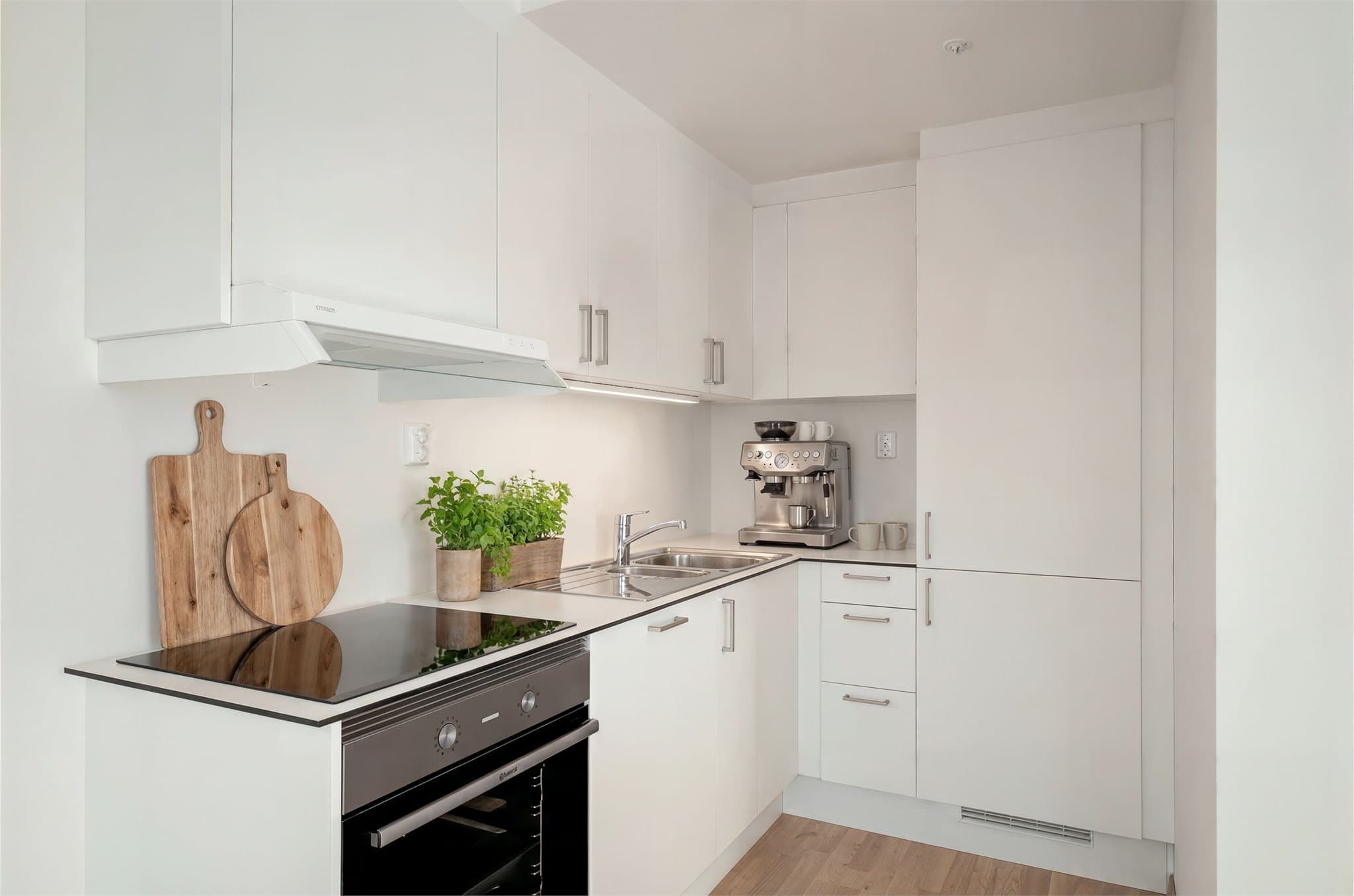 Illustrasjonsbilde - Kjøkkenet er lyst og tidløst med rikelig skap- og benkeplass, samt integrerte hvitevarer som gir et helhetlig uttrykk.