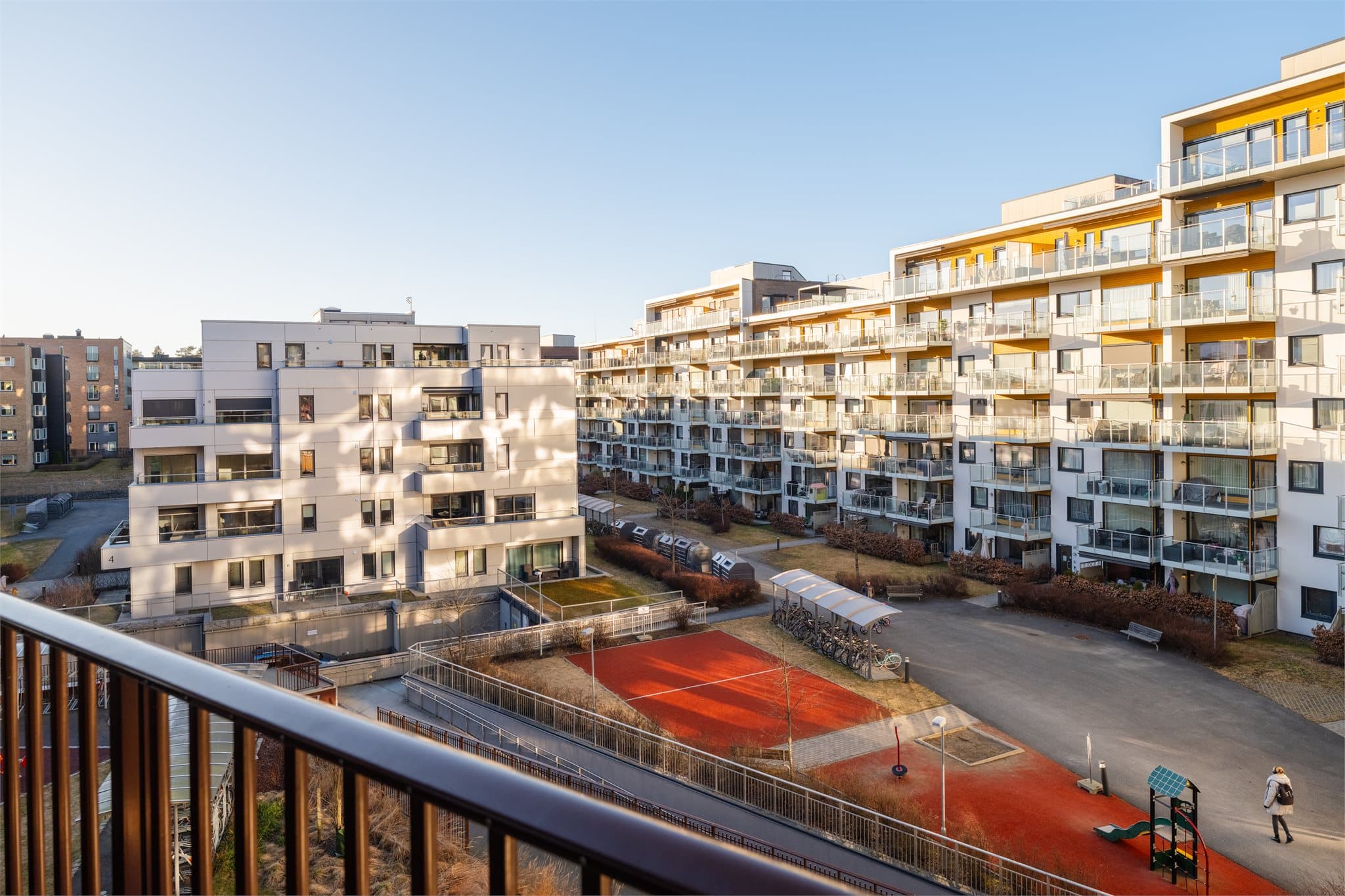 Utsikt over det familievennlige gårdsrommet med lekeplass og sosiale soner.