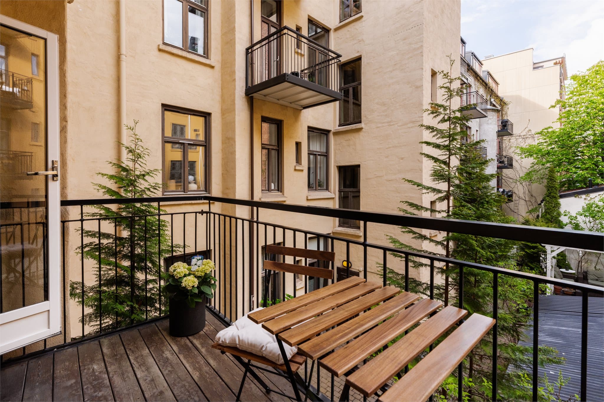 Balkongen er utført med terrassebord på gulvet og rekkverk i stål.