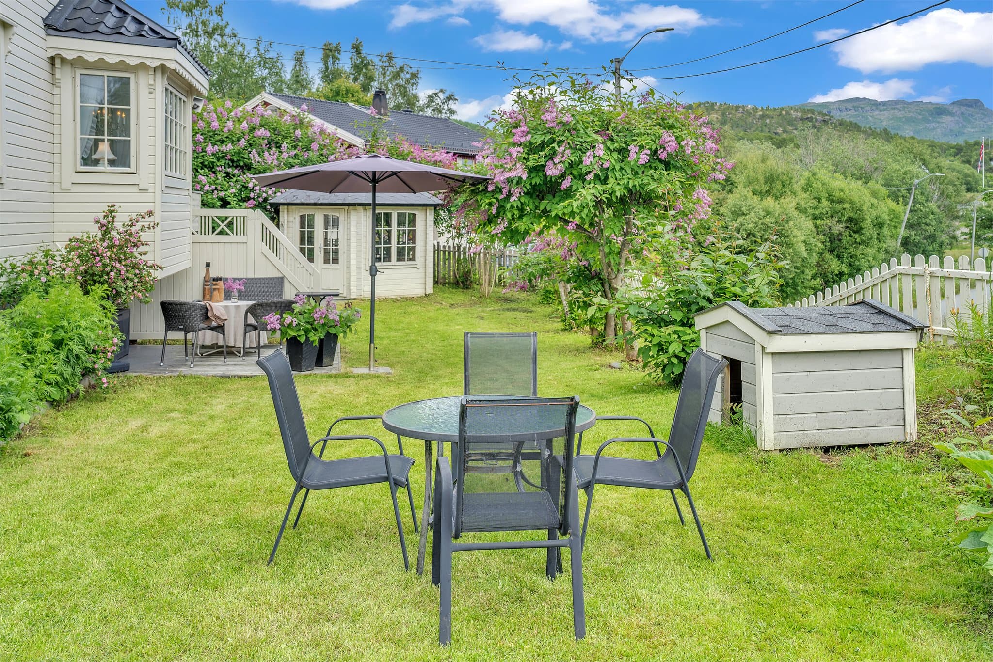 Stor, frodig hage med flere uteplasser og et sjarmerende lysthus.