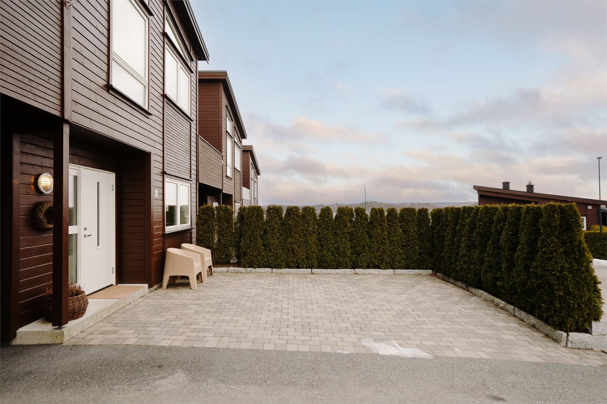 Eiendommen er pent opparbeidet med belegningsstein på gårdsplassen foran inngangen.