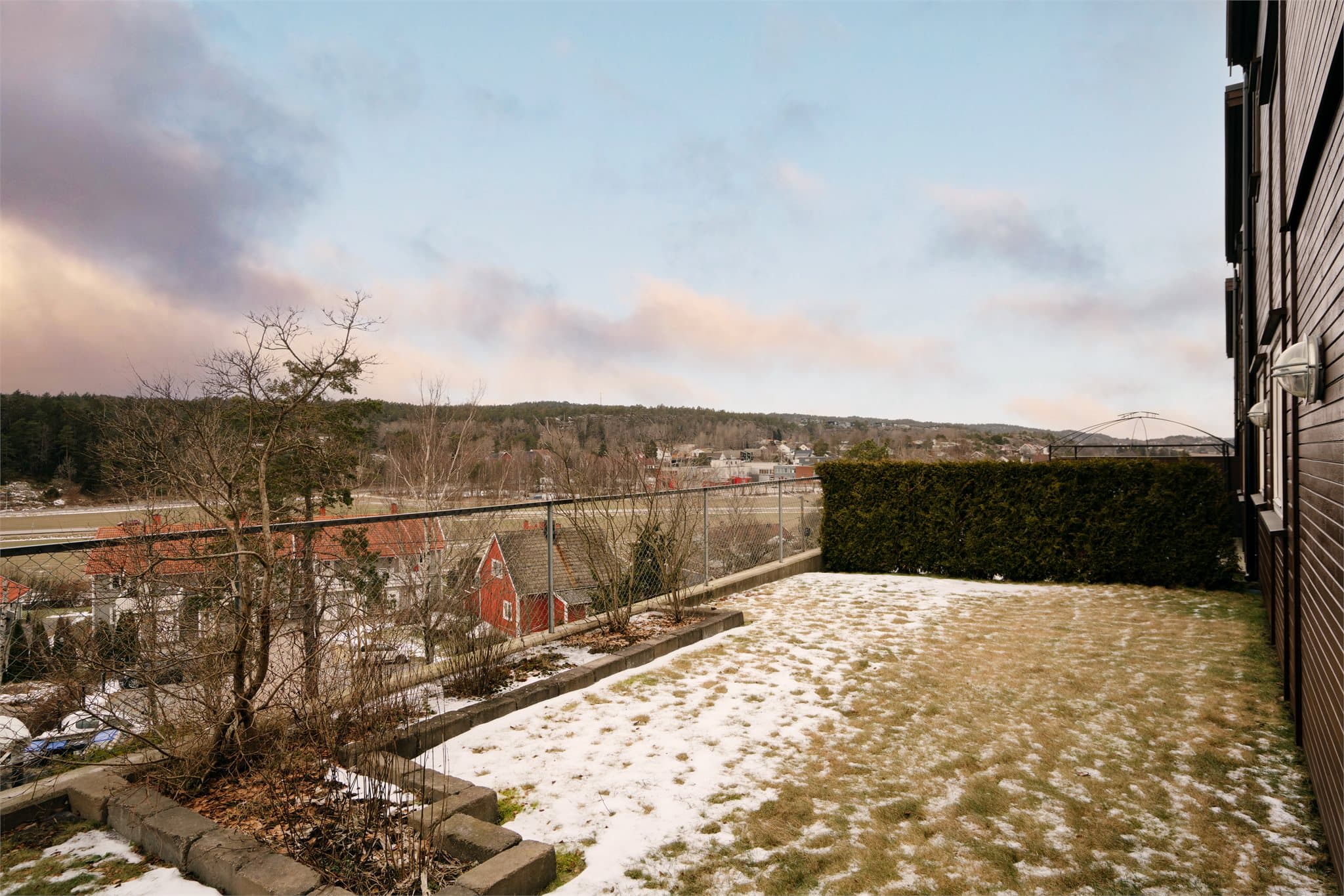 Uteområdet er opparbeidet med plen og hekk, og grenser mot fellesarealer.