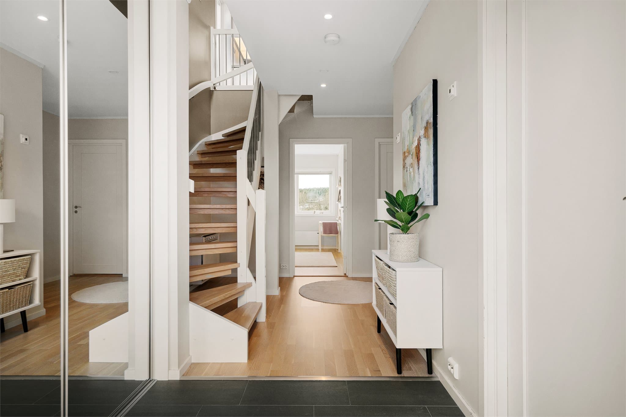 I første etasje ønskes du velkommen av en lys og innbydende entré med god oppbevaringsplass for sko og yttertøy i garderobeskap med speil-skyvedører.